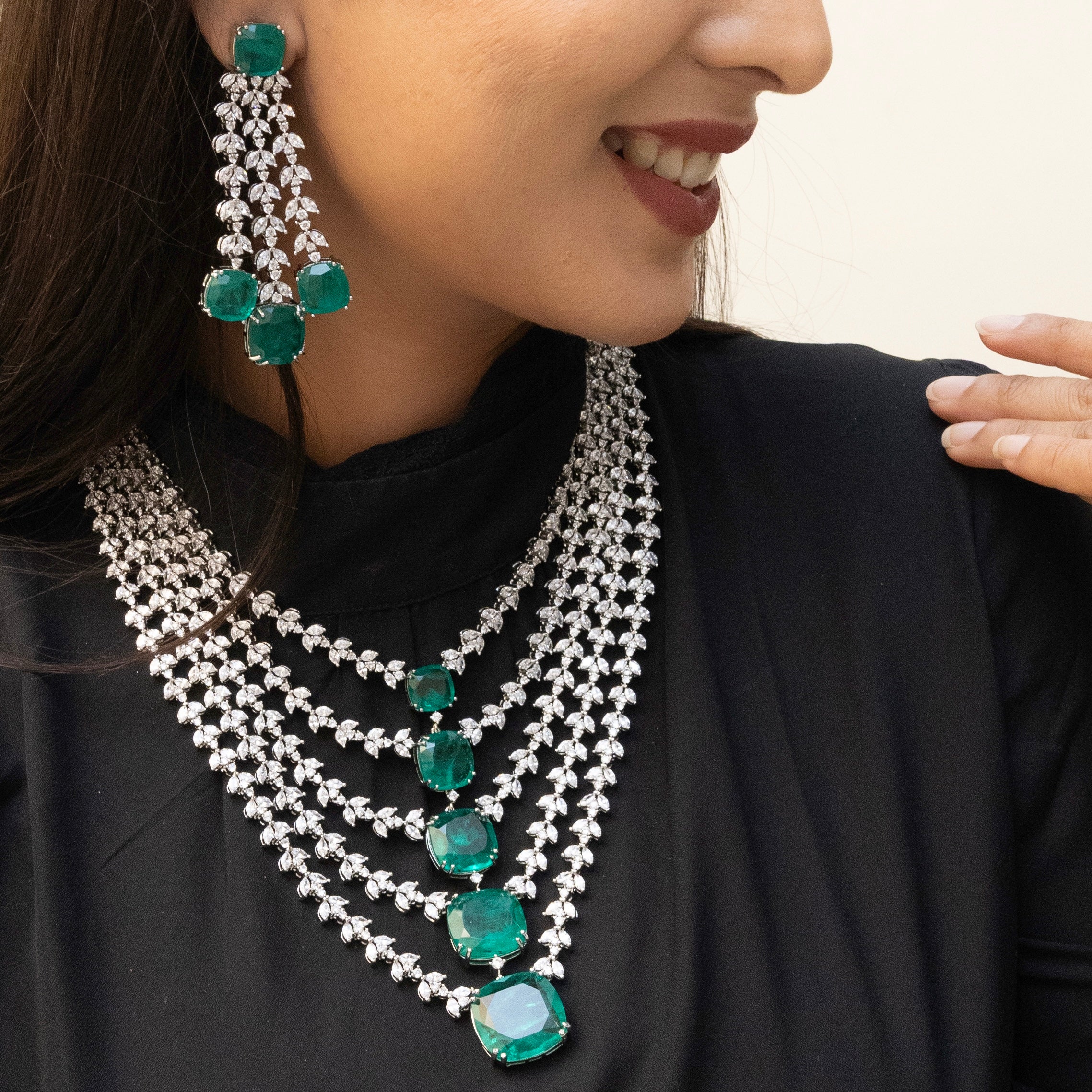 Close-up of emerald and diamond layered necklace highlighting stone brilliance