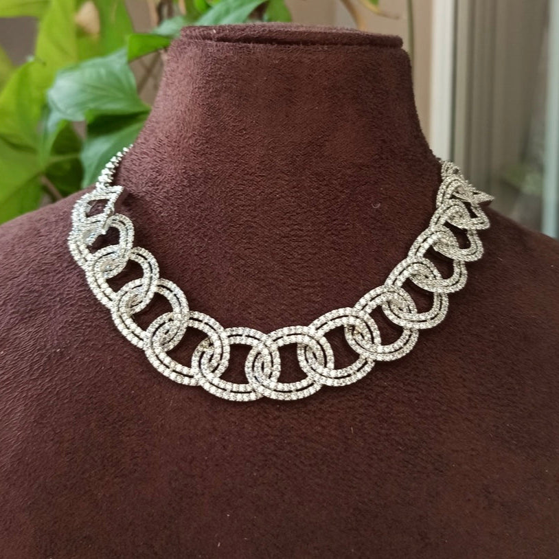 Side view of bold necklace featuring circular chain links and dazzling stone detailing
