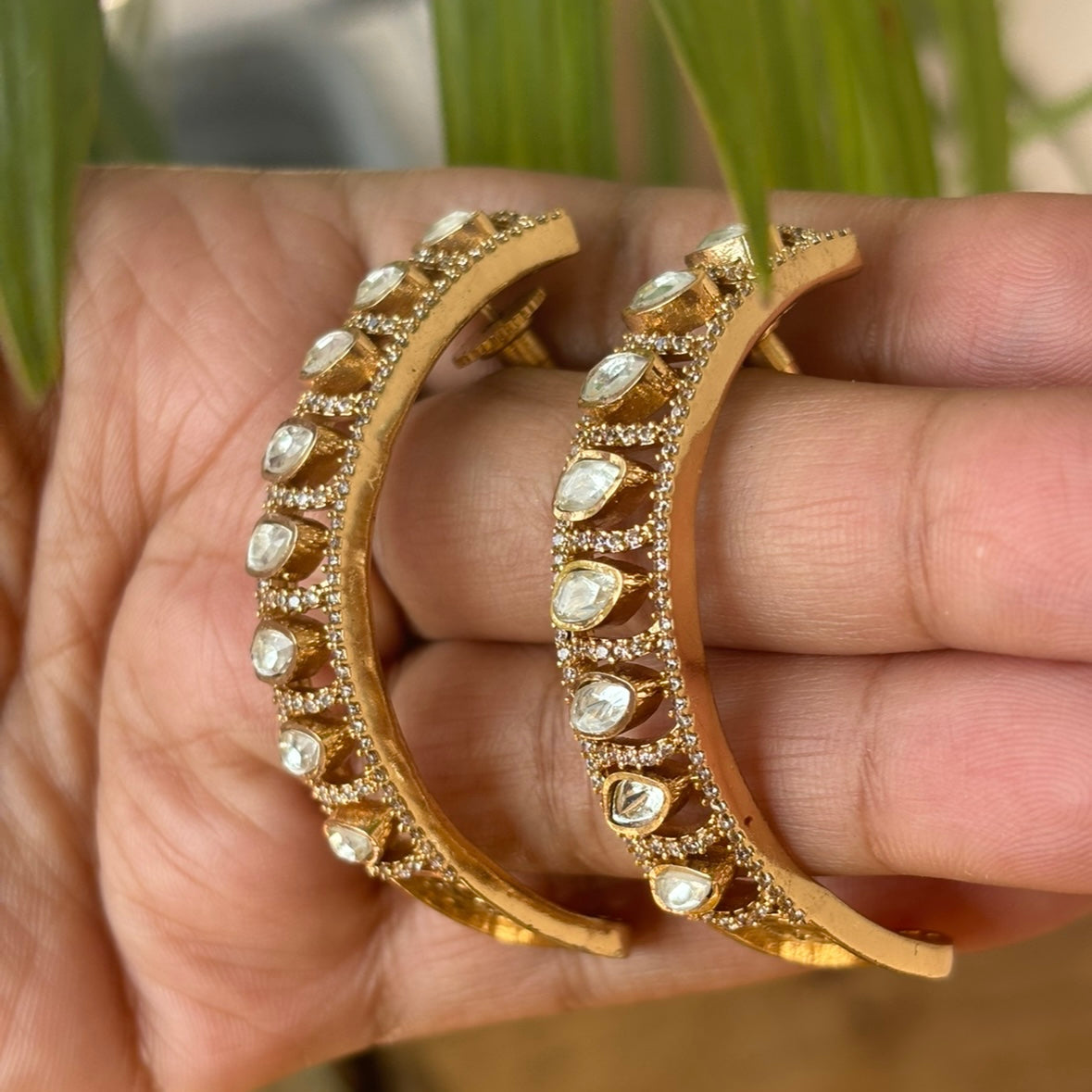 Side view of radiant arc earrings with polki diamonds and fine metal craftsmanship