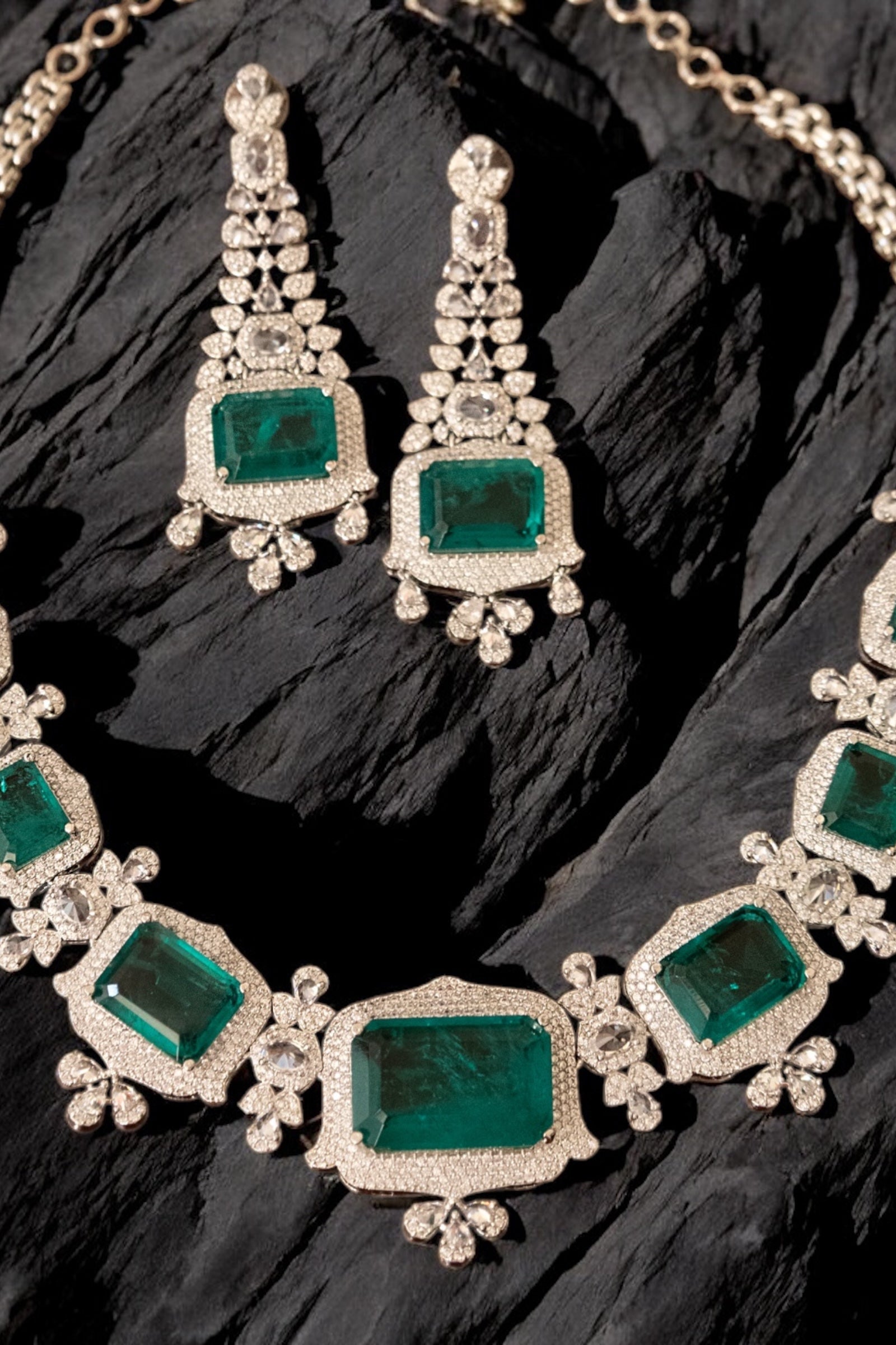 Side angle of green gemstone necklace highlighting emerald stones and diamond accents