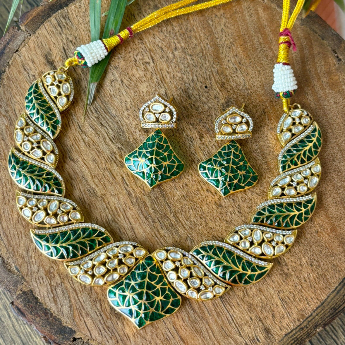 Side angle of nature-inspired kundan necklace with emerald enamel work
