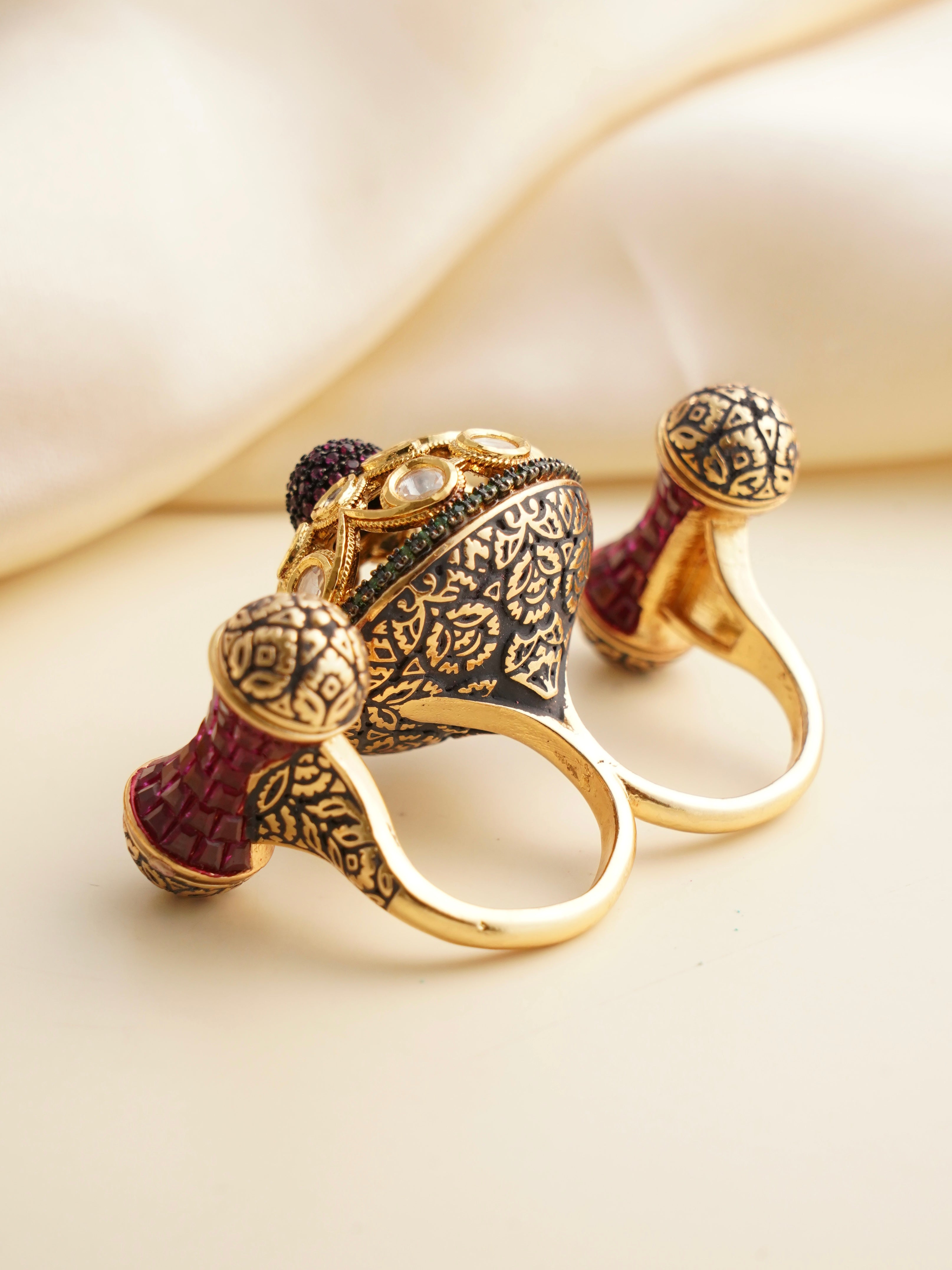 Side view of double finger ring with ruby accents and statement gold frame