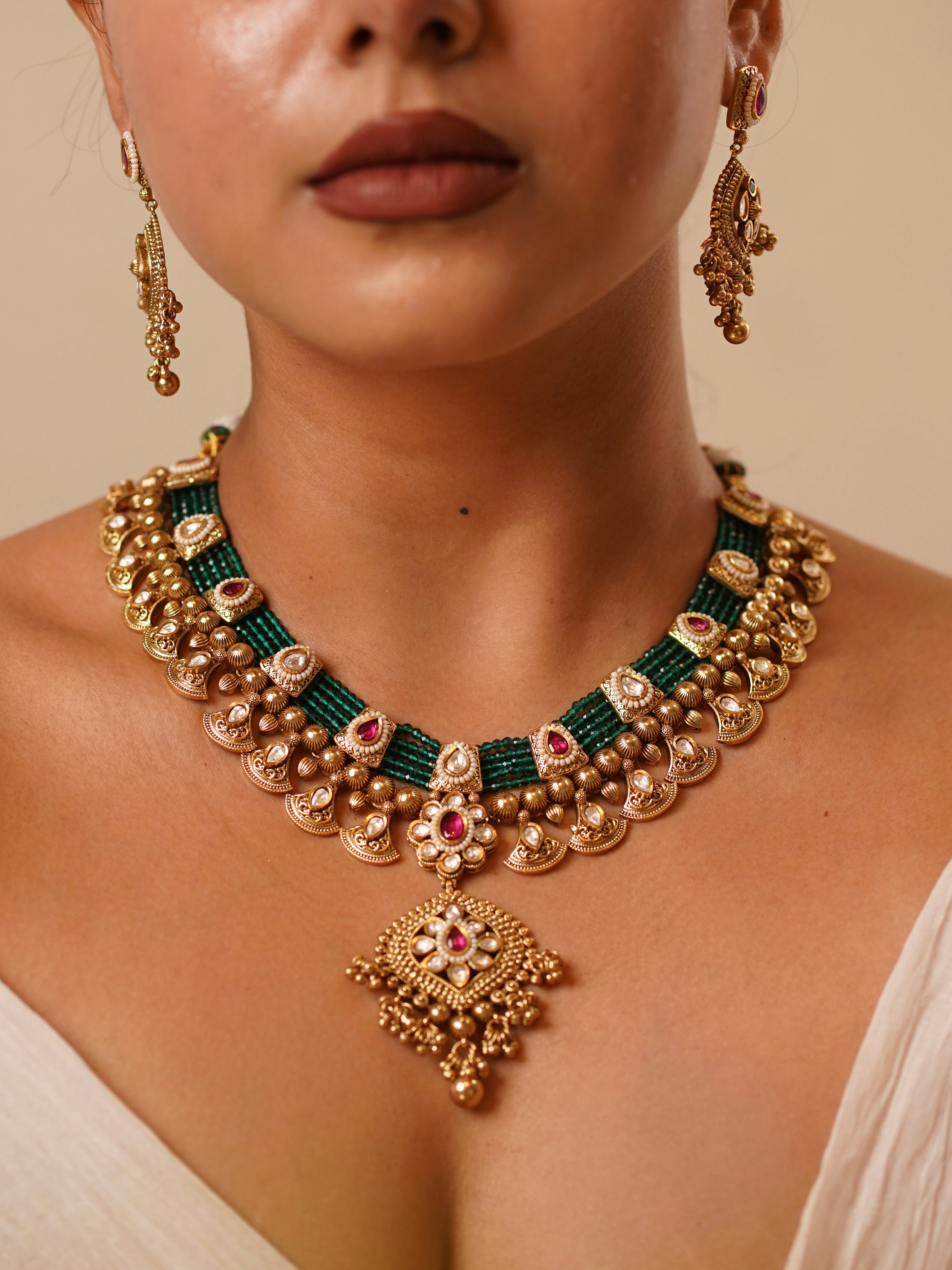 Side view of Meher Antique Empress necklace showing layered emerald beads and ruby accents