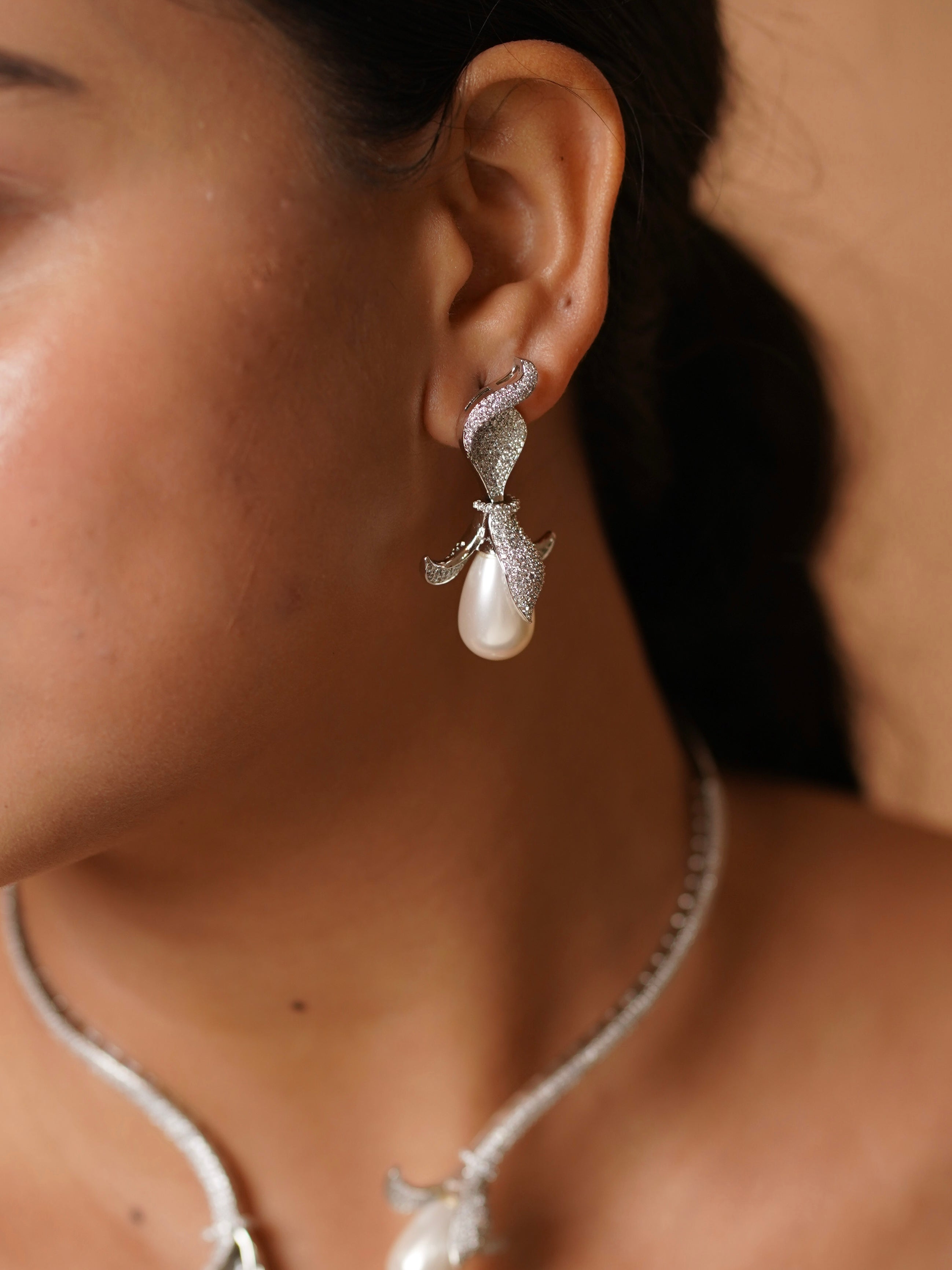 Close-up of diamond pearl necklace showing curved leaves and central drop pearl