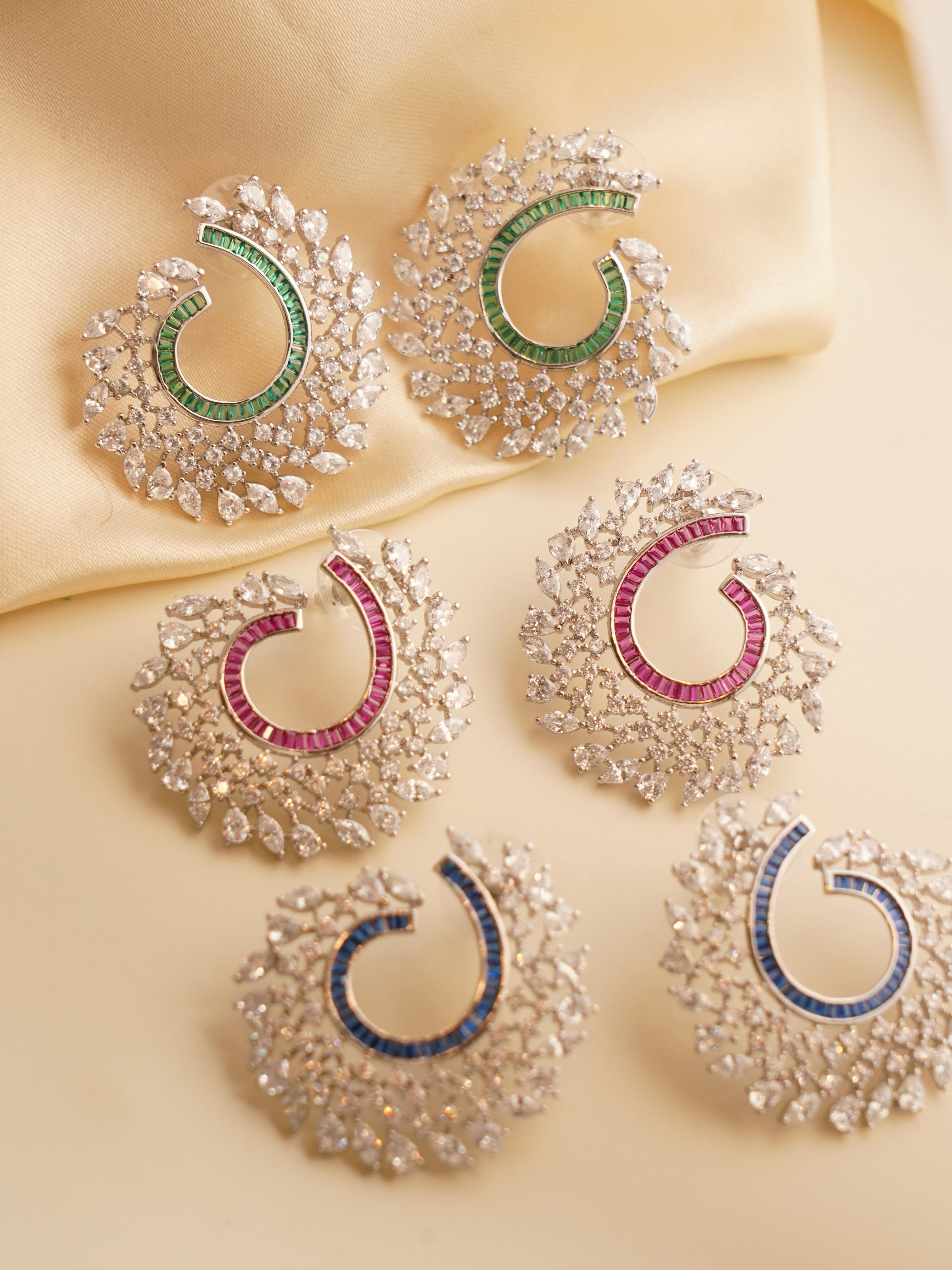 Top-down view highlighting multicolor baguette stones in a bold spiral earring design