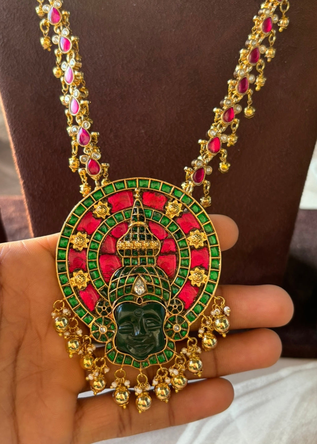 Close-up of temple jewellery pendant with enamel accents and kundan stone embellishments