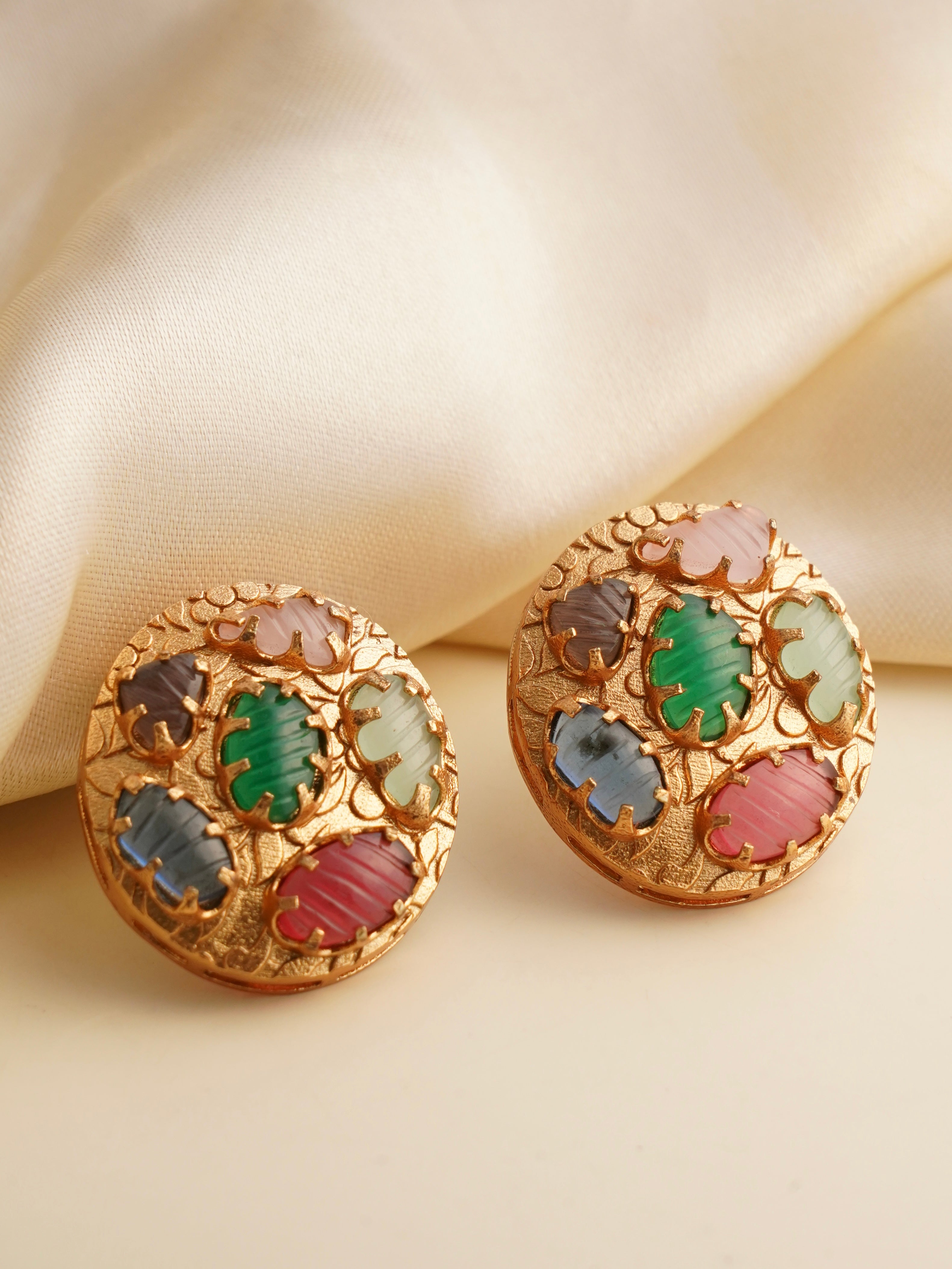Navratna carved medallion studs with multicolored oval gemstones in a textured gold frame