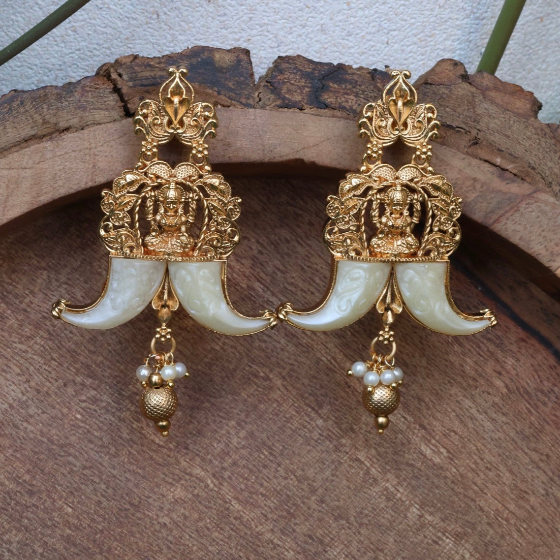 Close-up highlighting earrings’ curved silhouette and modern gold-toned finish