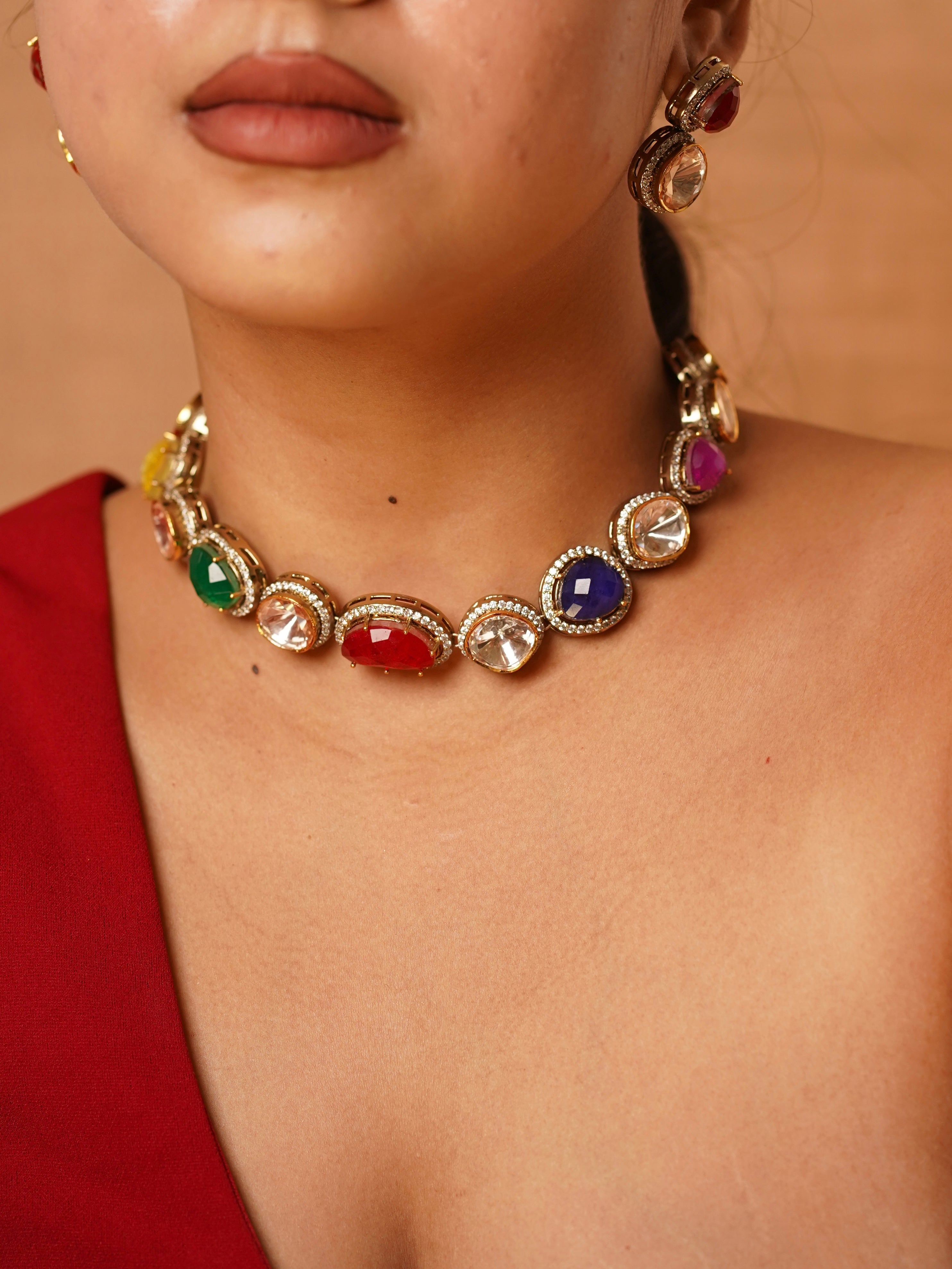 Close-up of navratna choker featuring nine colourful gemstones framed by polki and gold settings