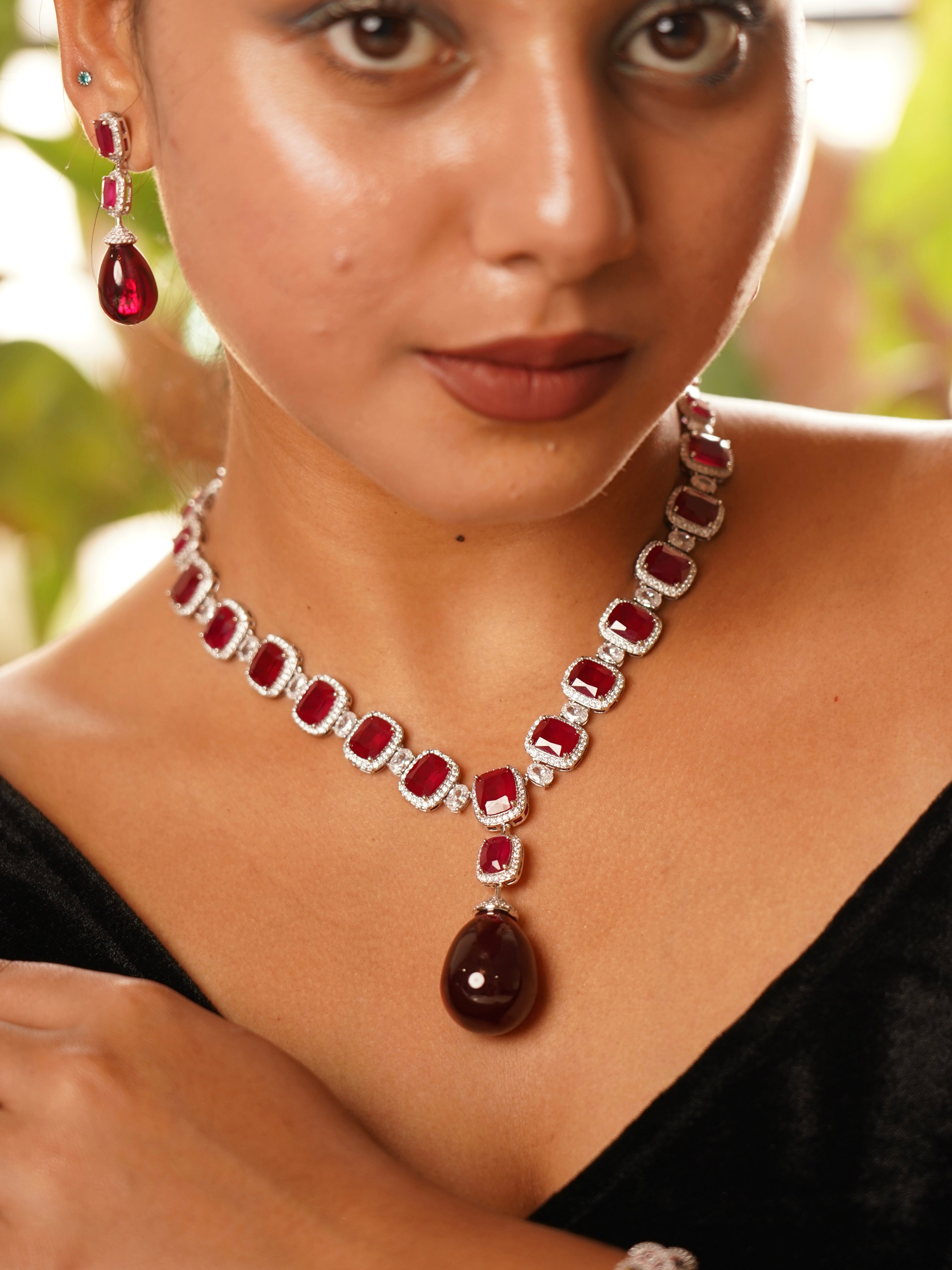 Close-up of matching ruby earrings and pendant from the empress ruby suite