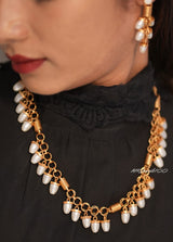 Angled view of statement necklace with chunky gold beads and bold ethnic design