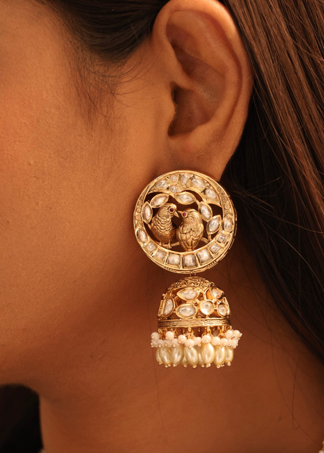 angled close-up of bird-themed jewellery set with pearls and stone embellishments