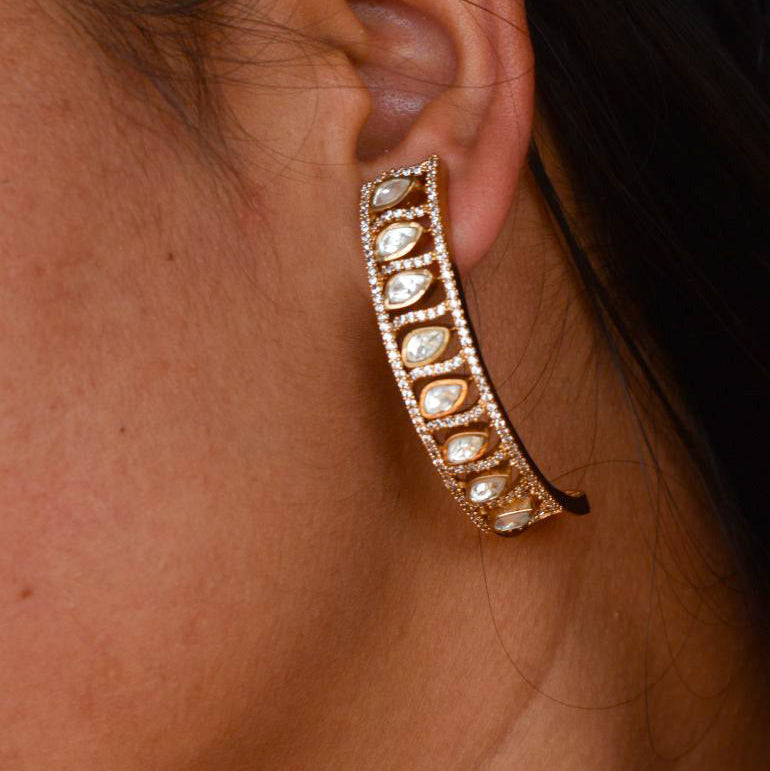 Arc earrings with teardrop polki diamonds set in a curved gold frame and sleek finish