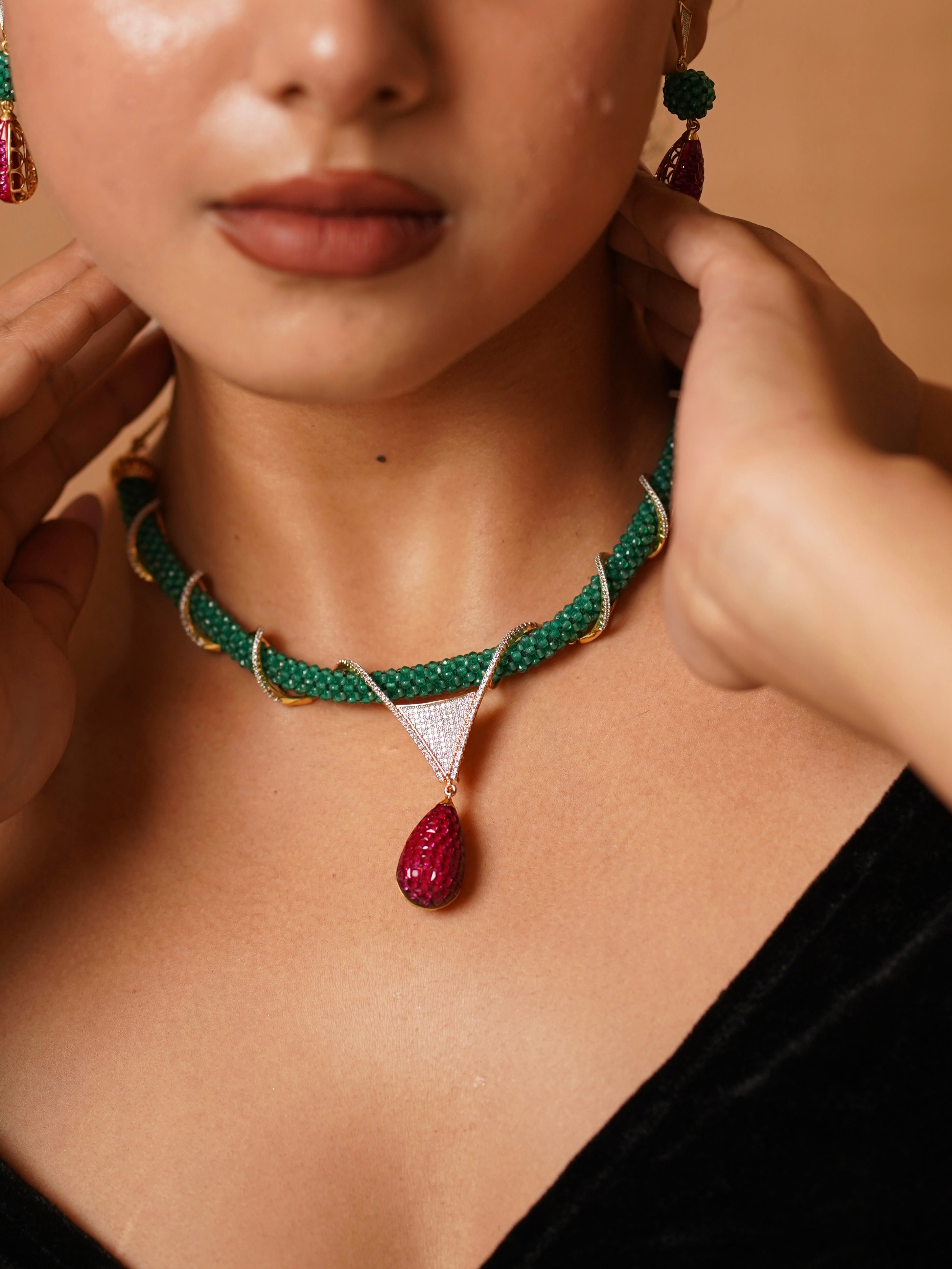 Front view of designer hasli set with ruby pendant and emerald-toned braid detail