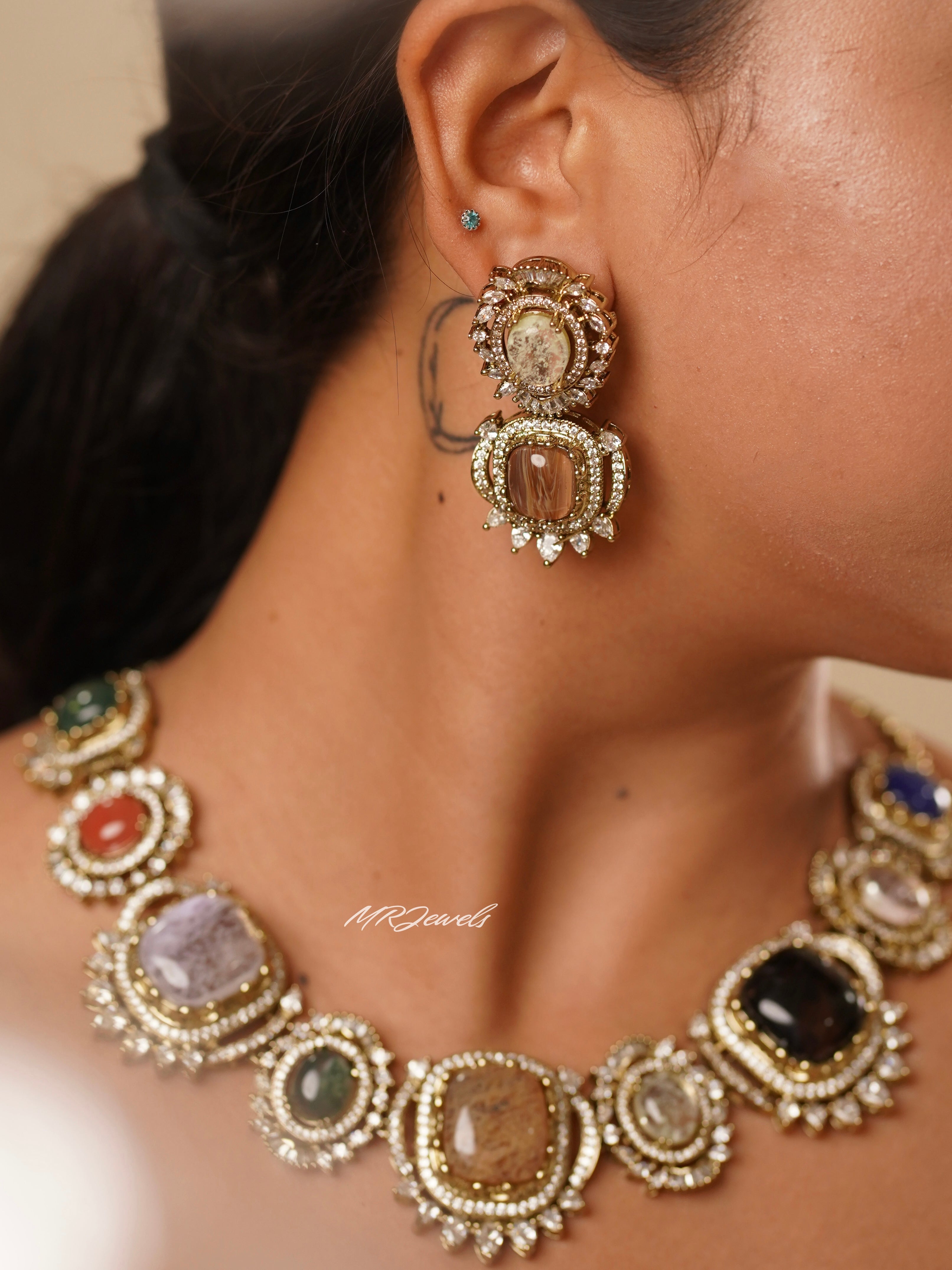 Side view of navratna set earrings and necklace with stacked heritage gemstones in antique finish