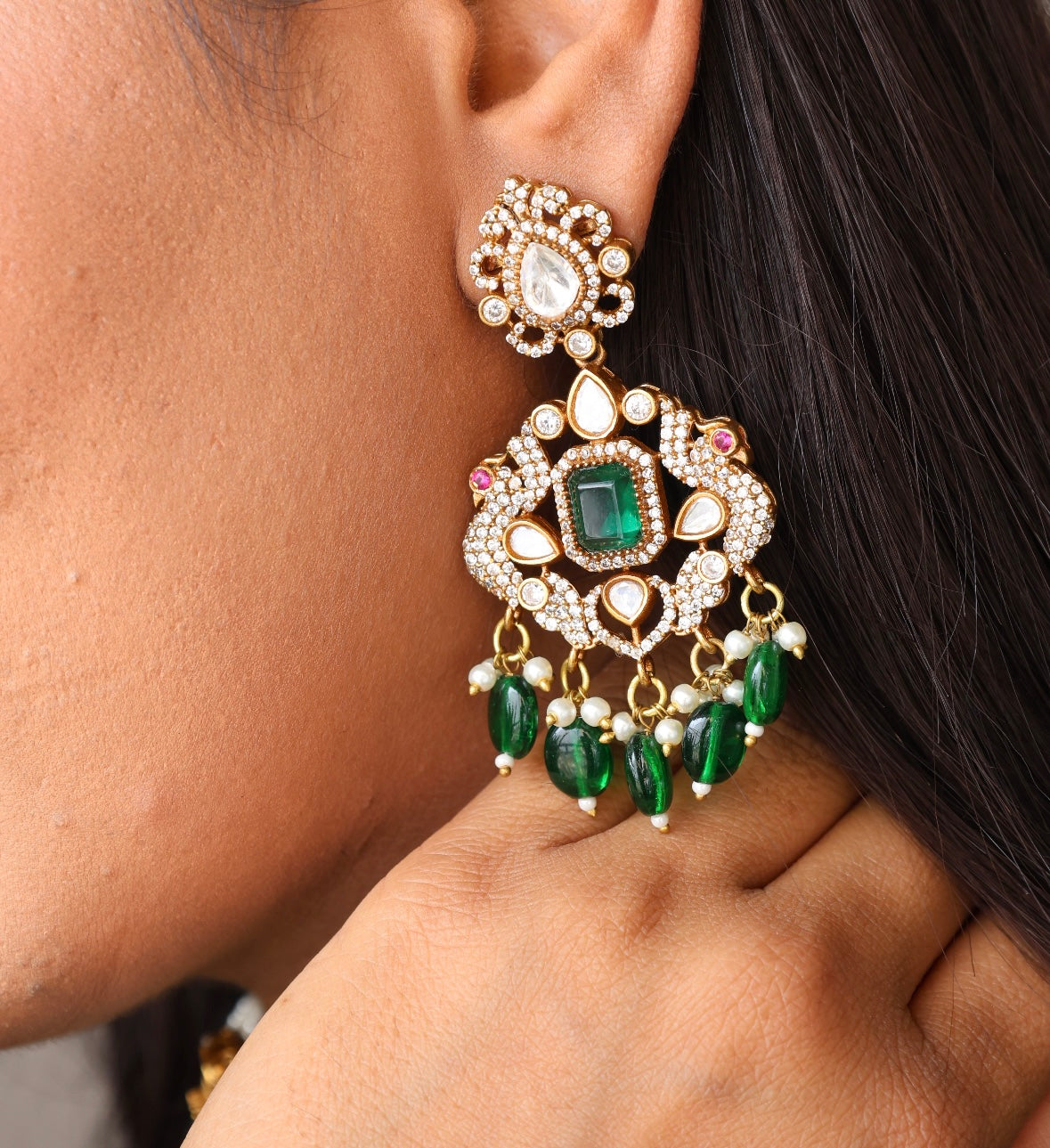 angled view of green choker with central kundan motif and detailed earring set
