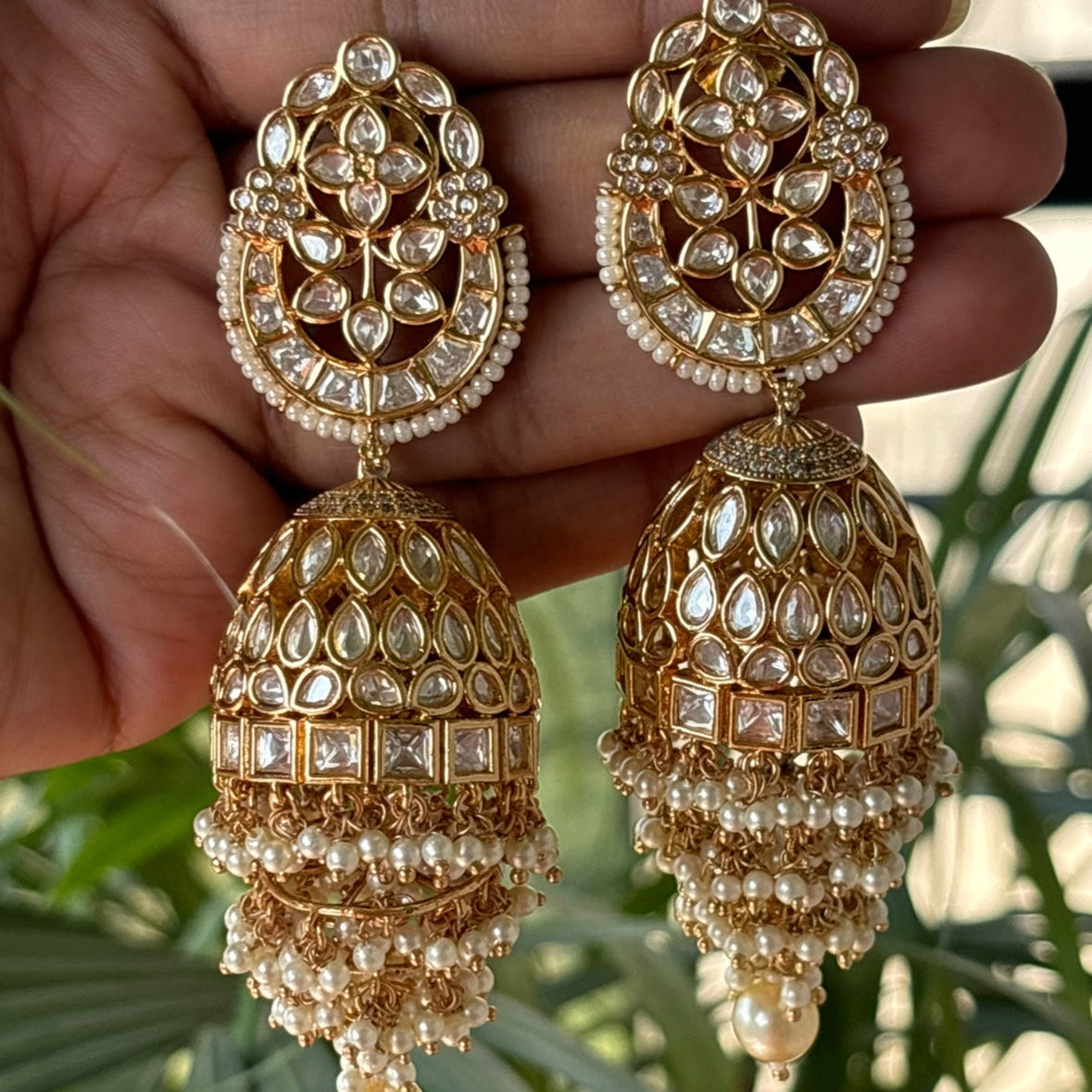 Side profile of pearl tassel jhumkas with floral kundan design