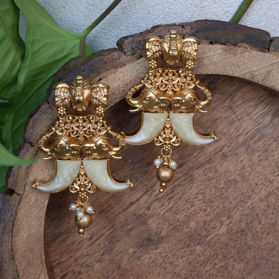 Side view of tusk earrings showing smooth arc and metallic polish