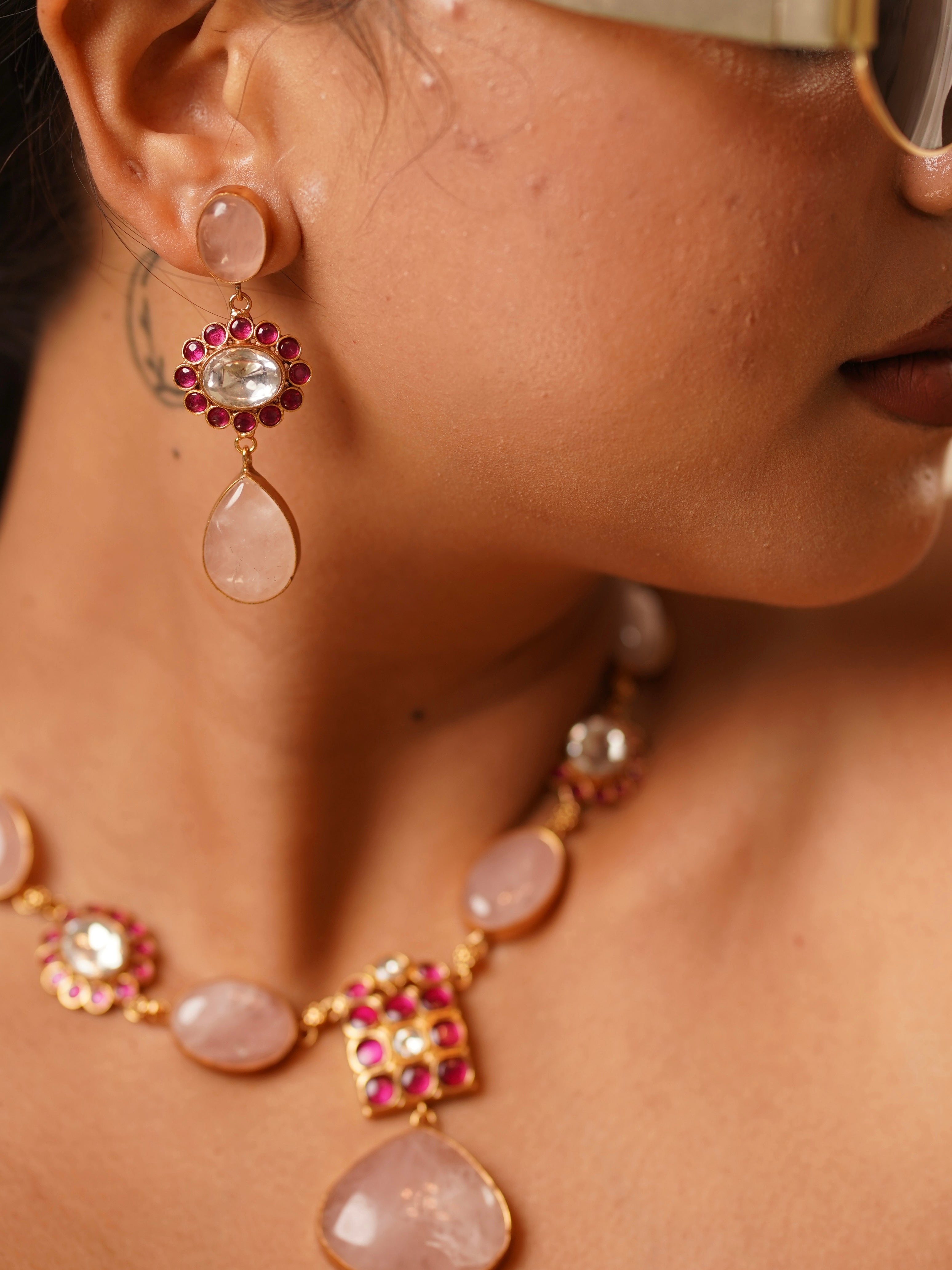 angled shot of kabachino kundan necklace set with deep green and red stone details