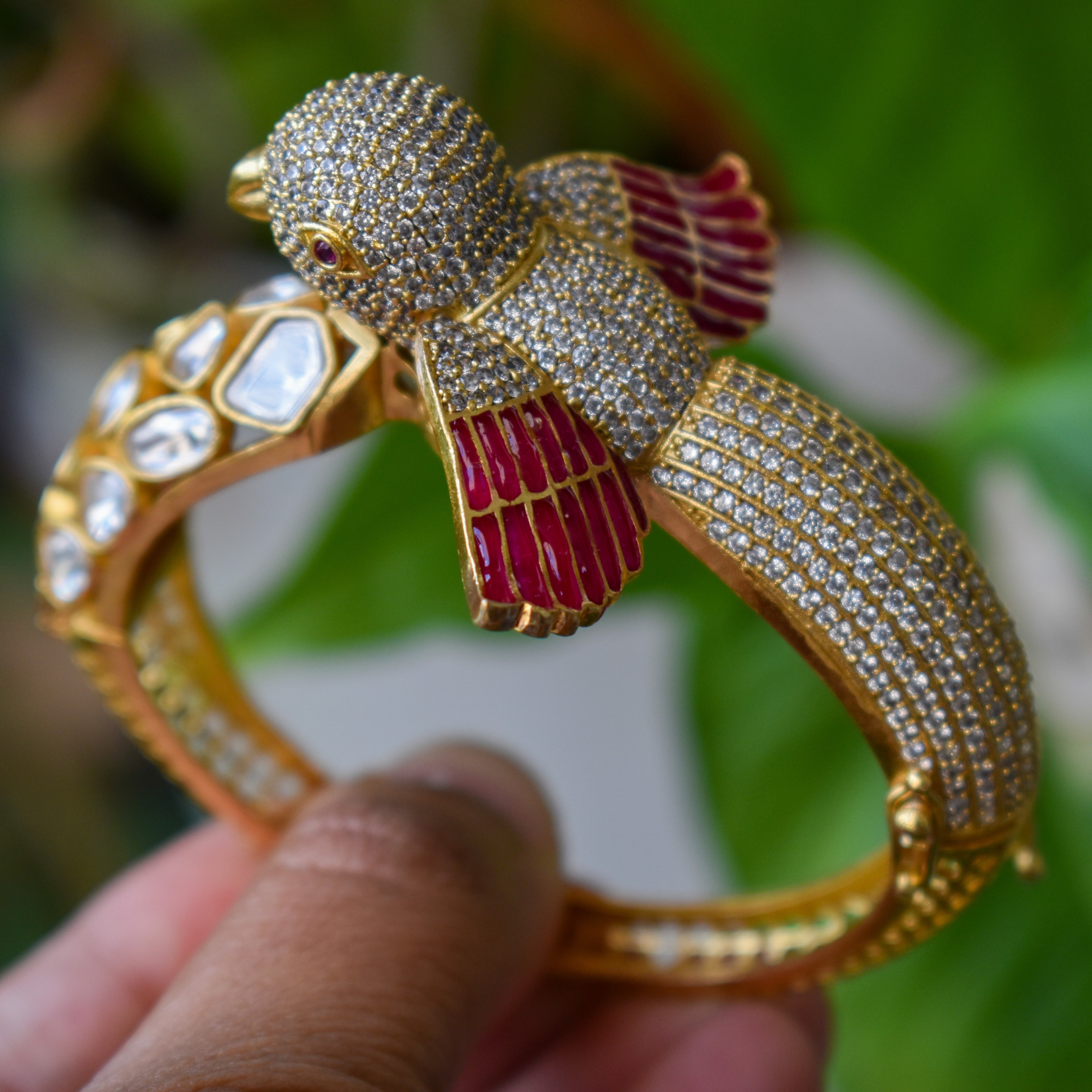 Openable kada with bird motif, red enamel wings and crystal embellishments, front view