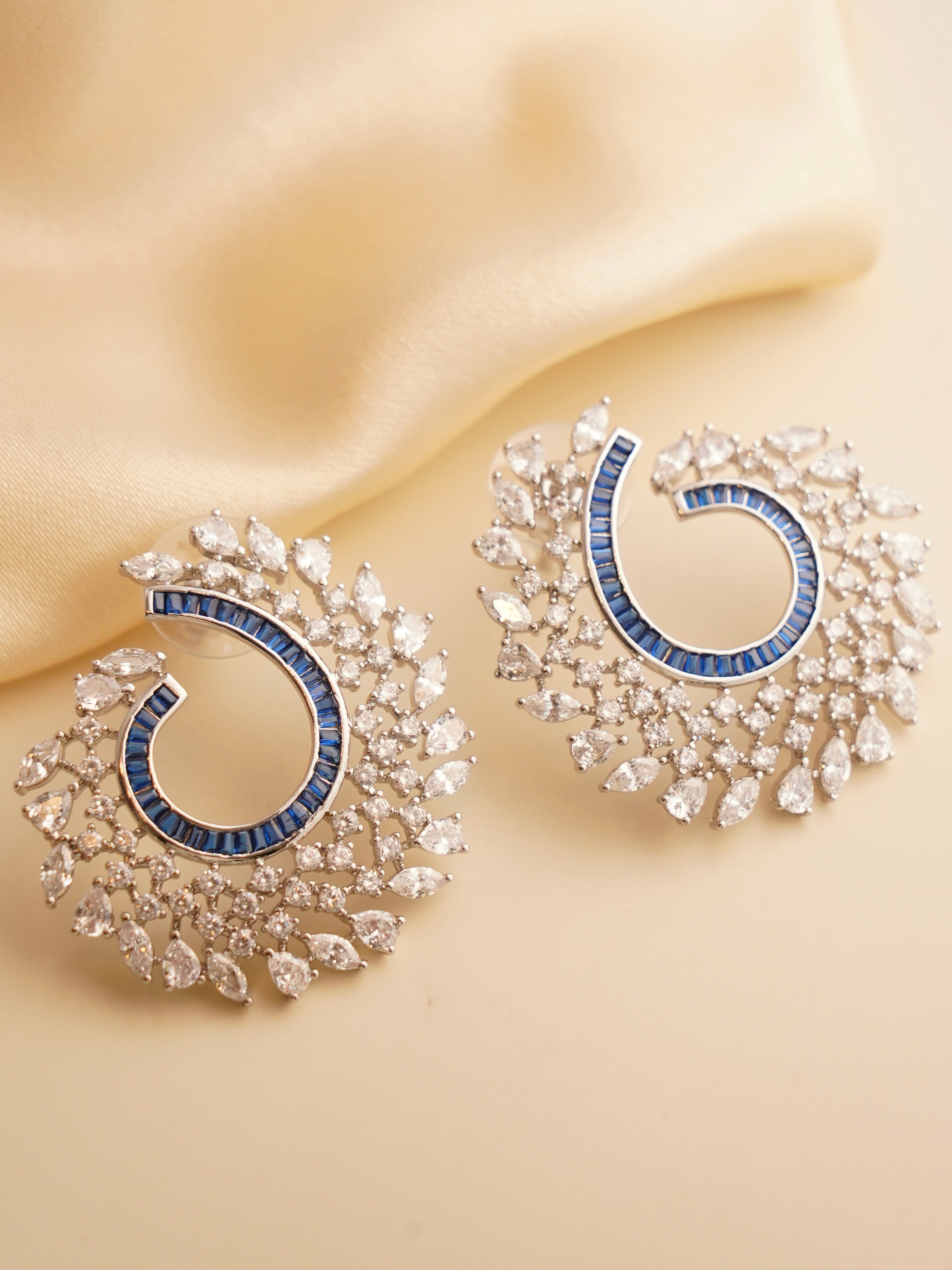 Spiral earrings with multicolored baguette stones in swirl design featuring ruby, emerald, and sapphire hues