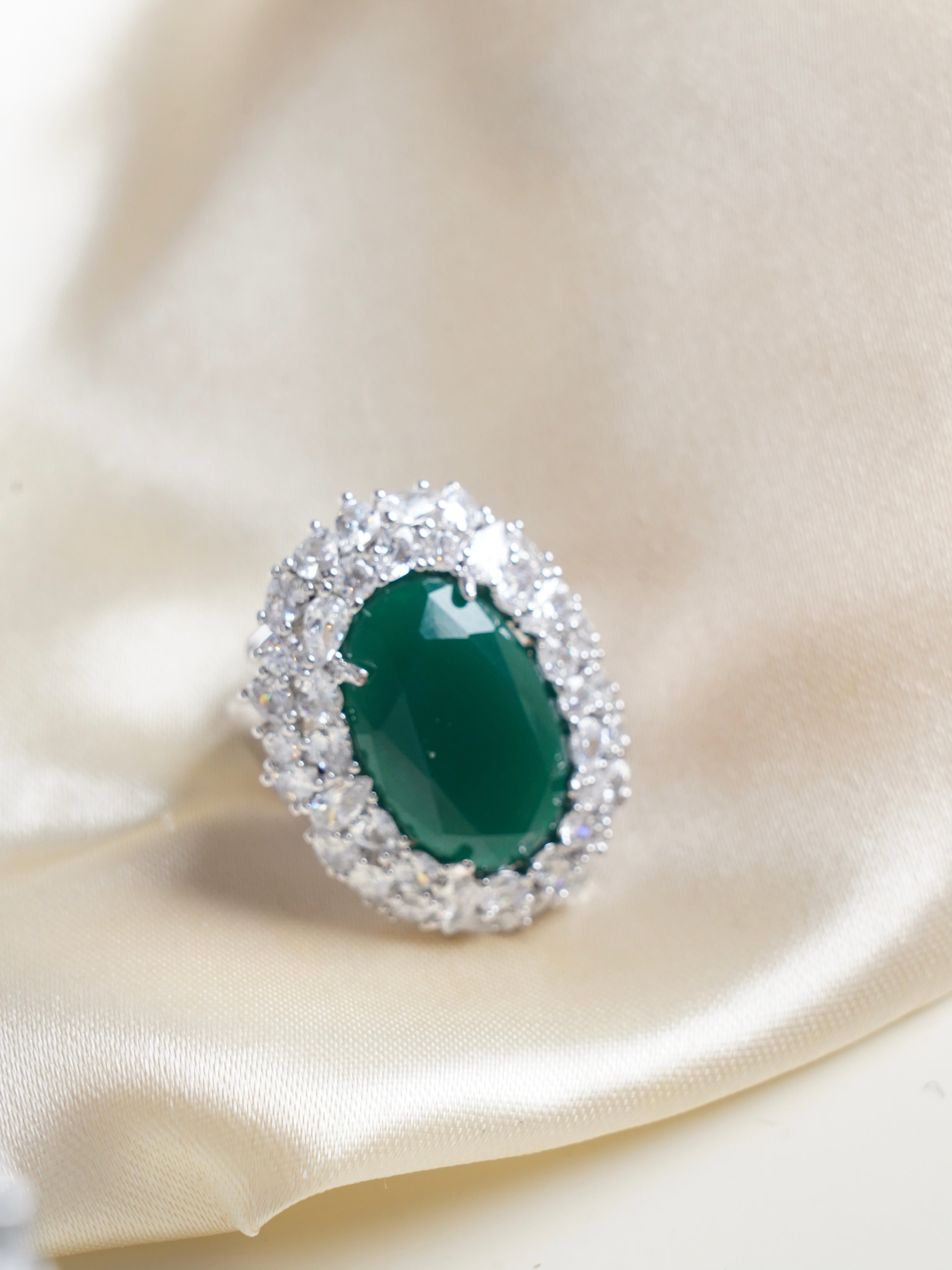 Close-up of emerald radiance ring highlighting cushion-cut green center and elegant crystal halo