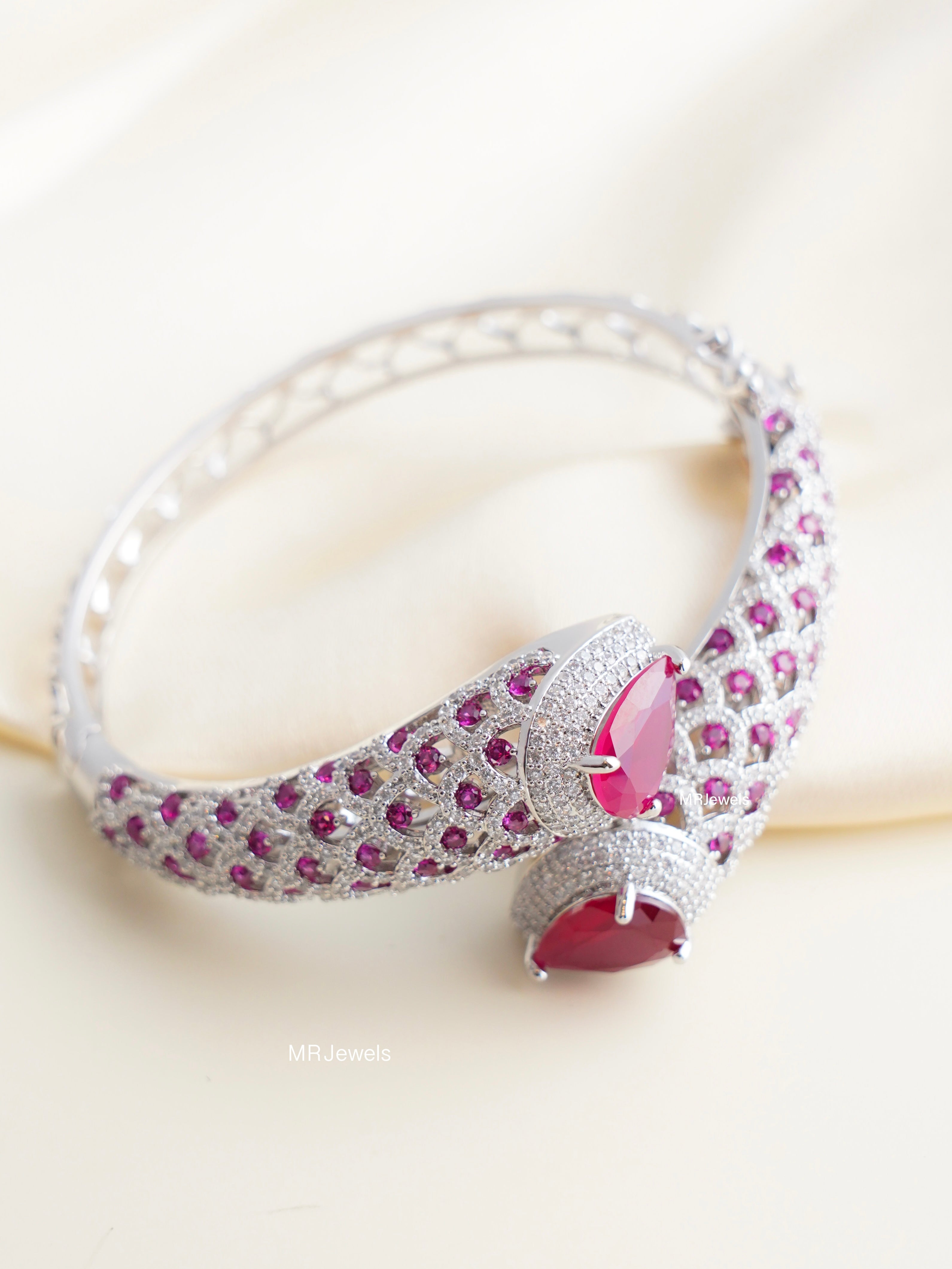 openable kada bracelet featuring twin pear‑cut ruby stones and lattice pavé cz setting