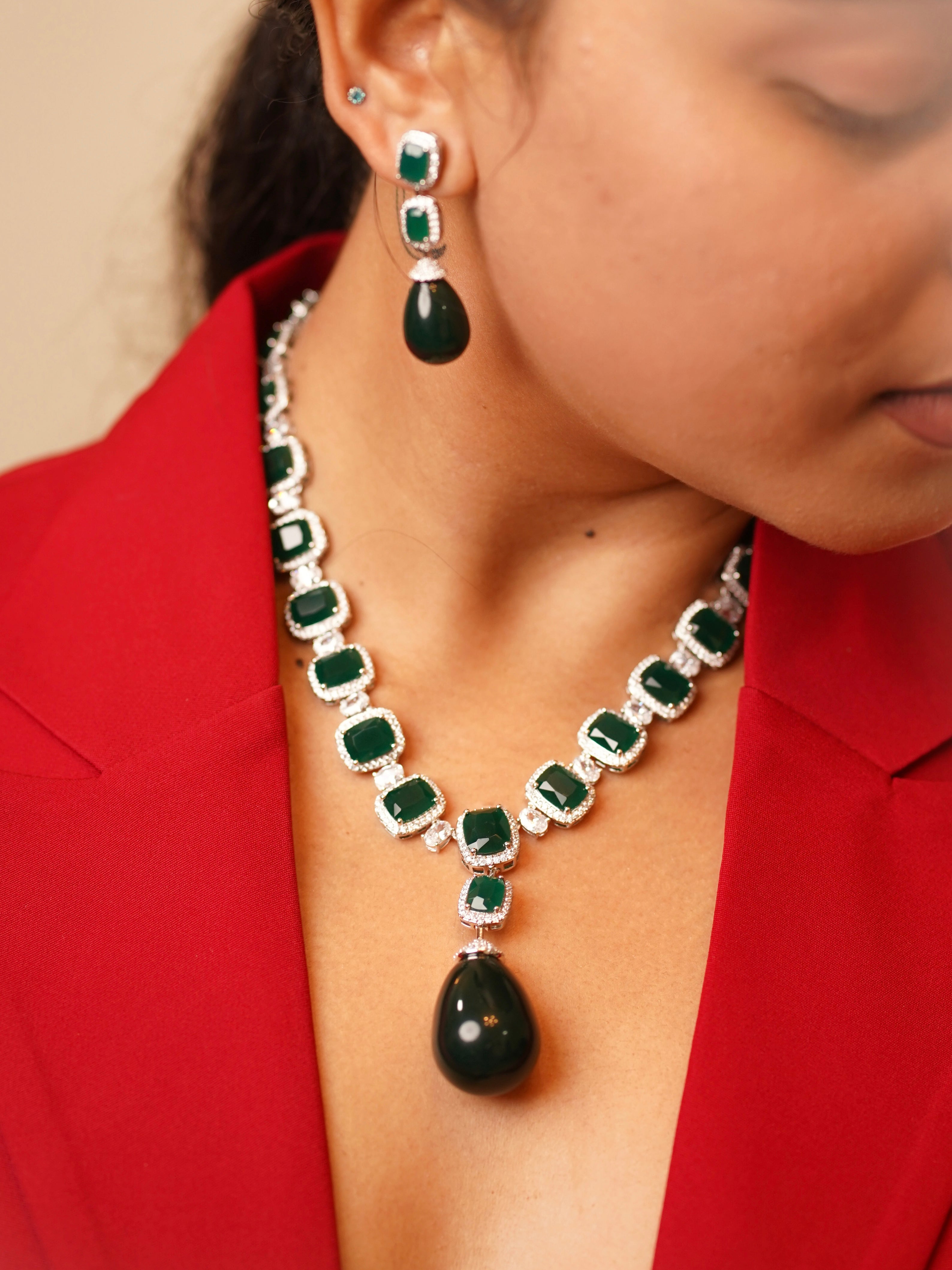 Front view of the empress emerald suite with baguette-cut green stones and teardrop pendant centerpiece