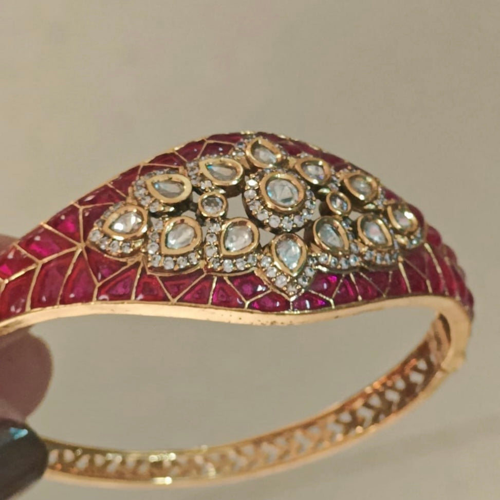 Angled view of gold-plated bracelet with polki Kundan stones and mosaic enamel