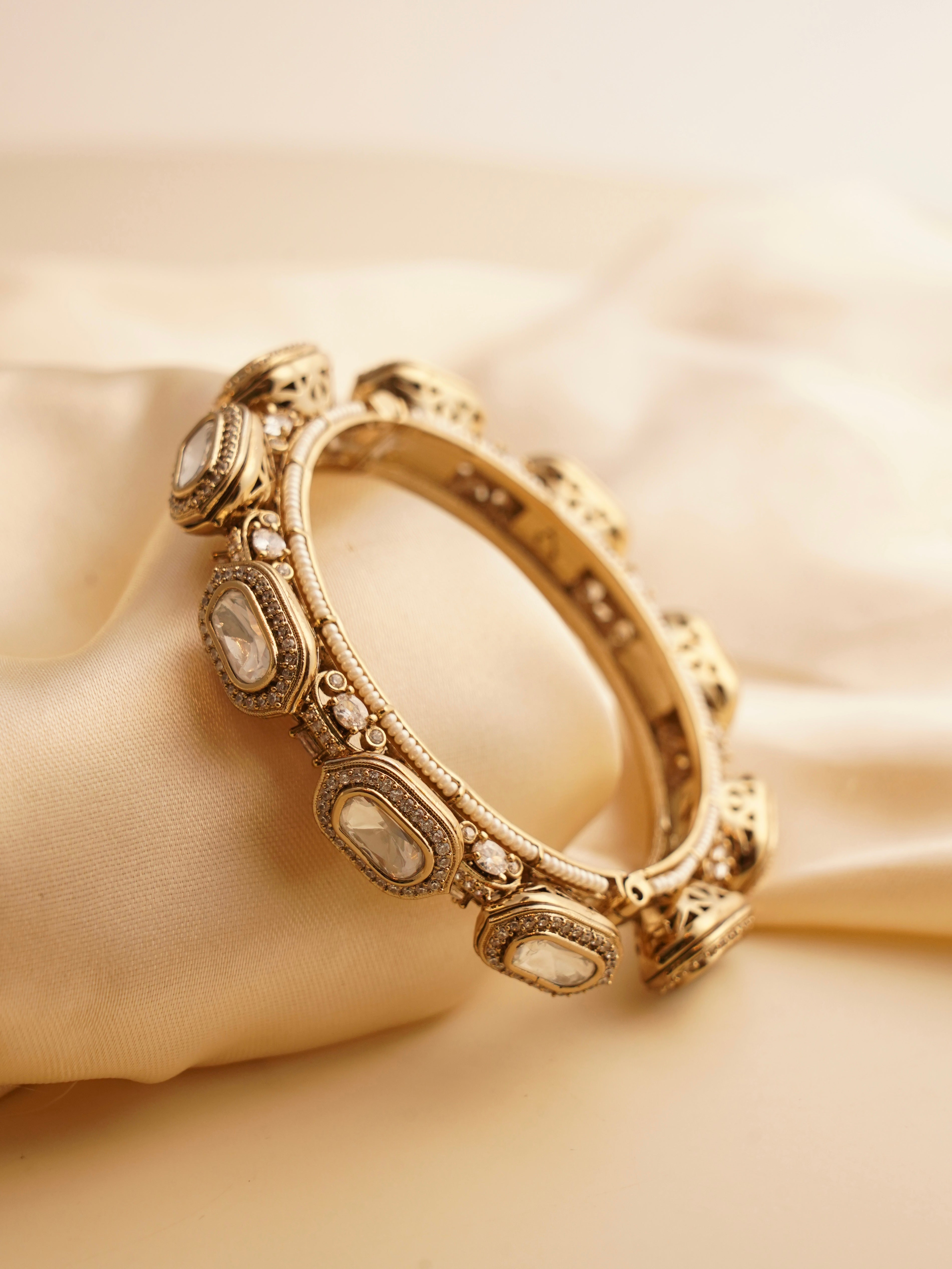 Close-up of paired kundan moissanite bangles in antique finish and fine setting
