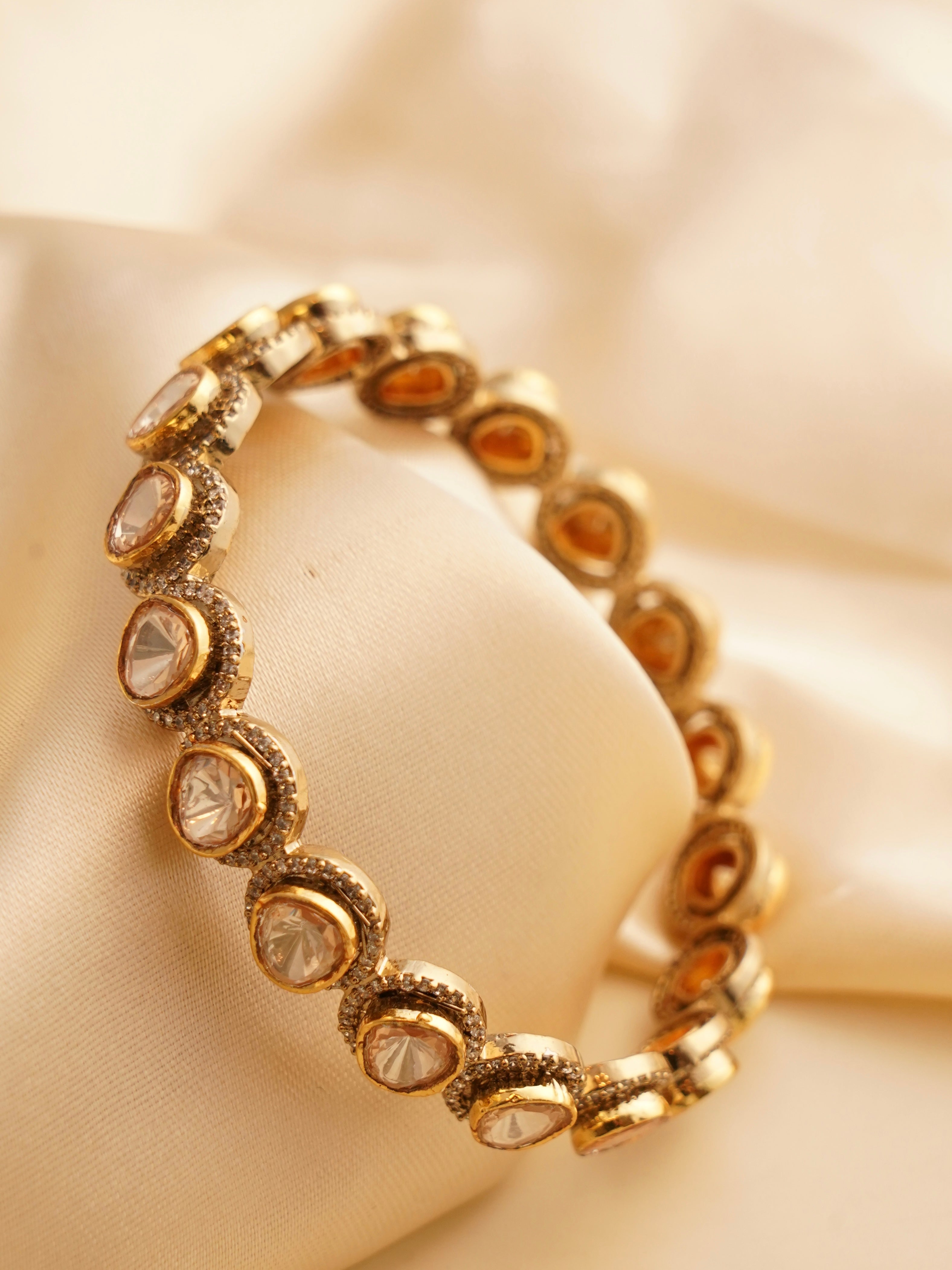 Side view of moissanite gold bangle highlighting round stone placements and sleek edges