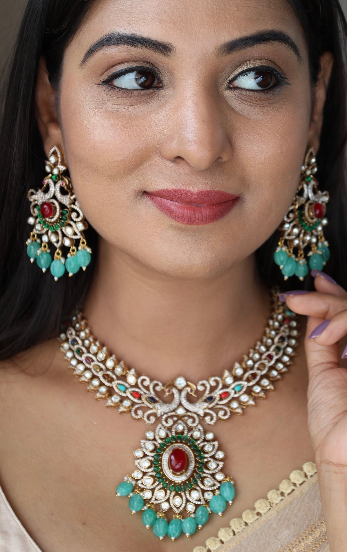 emerald beaded necklace with ruby center and gold peacock motifs, paired with earrings