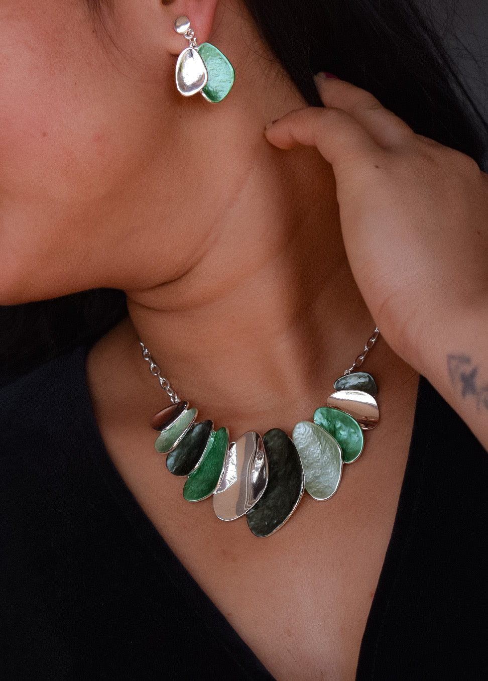 close-up of black and silver enamel necklace with layered shapes and textured finish