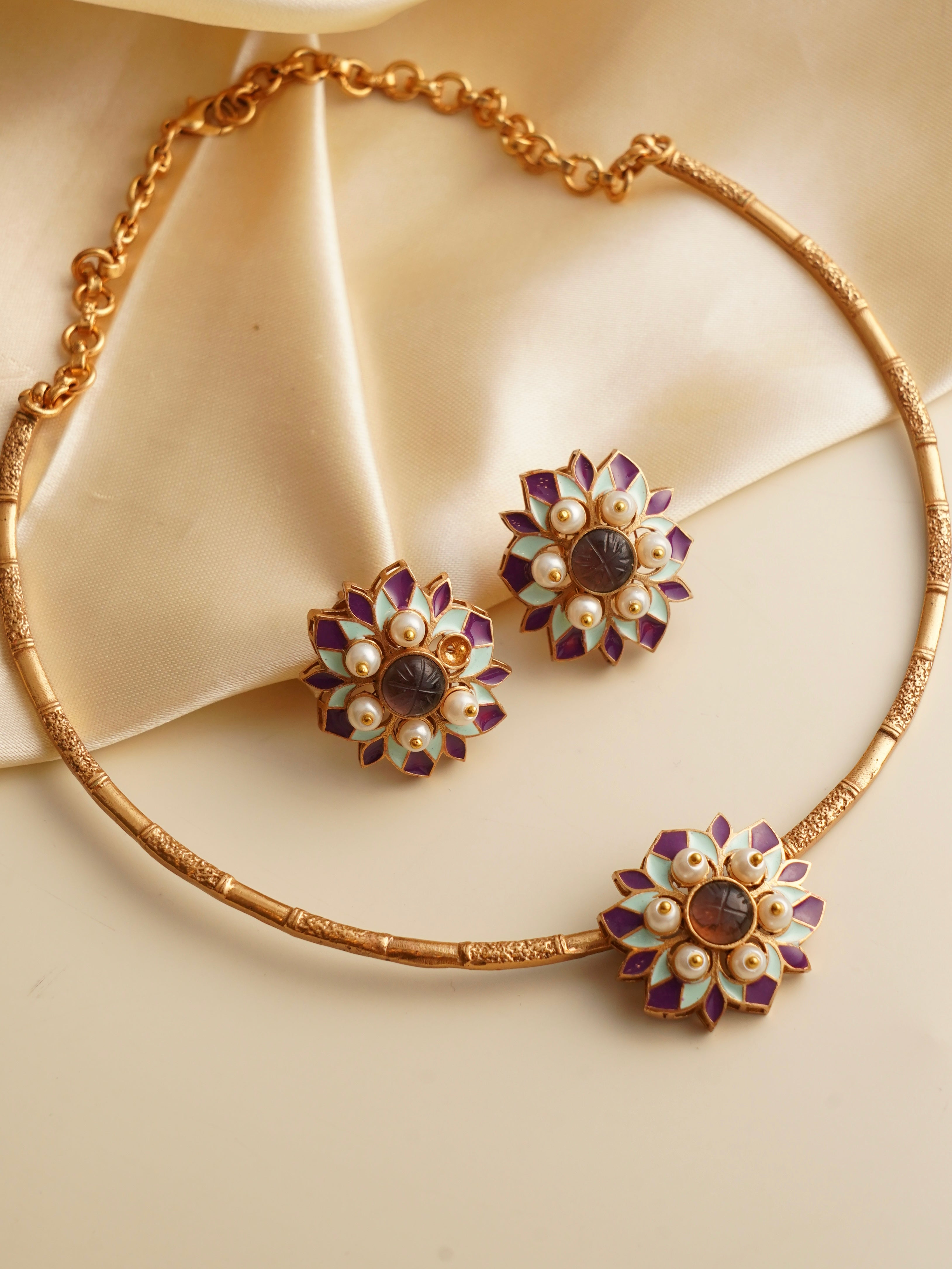 Myra Muse Hasli set featuring textured gold necklace with enamel floral motifs, pearls and matching studs