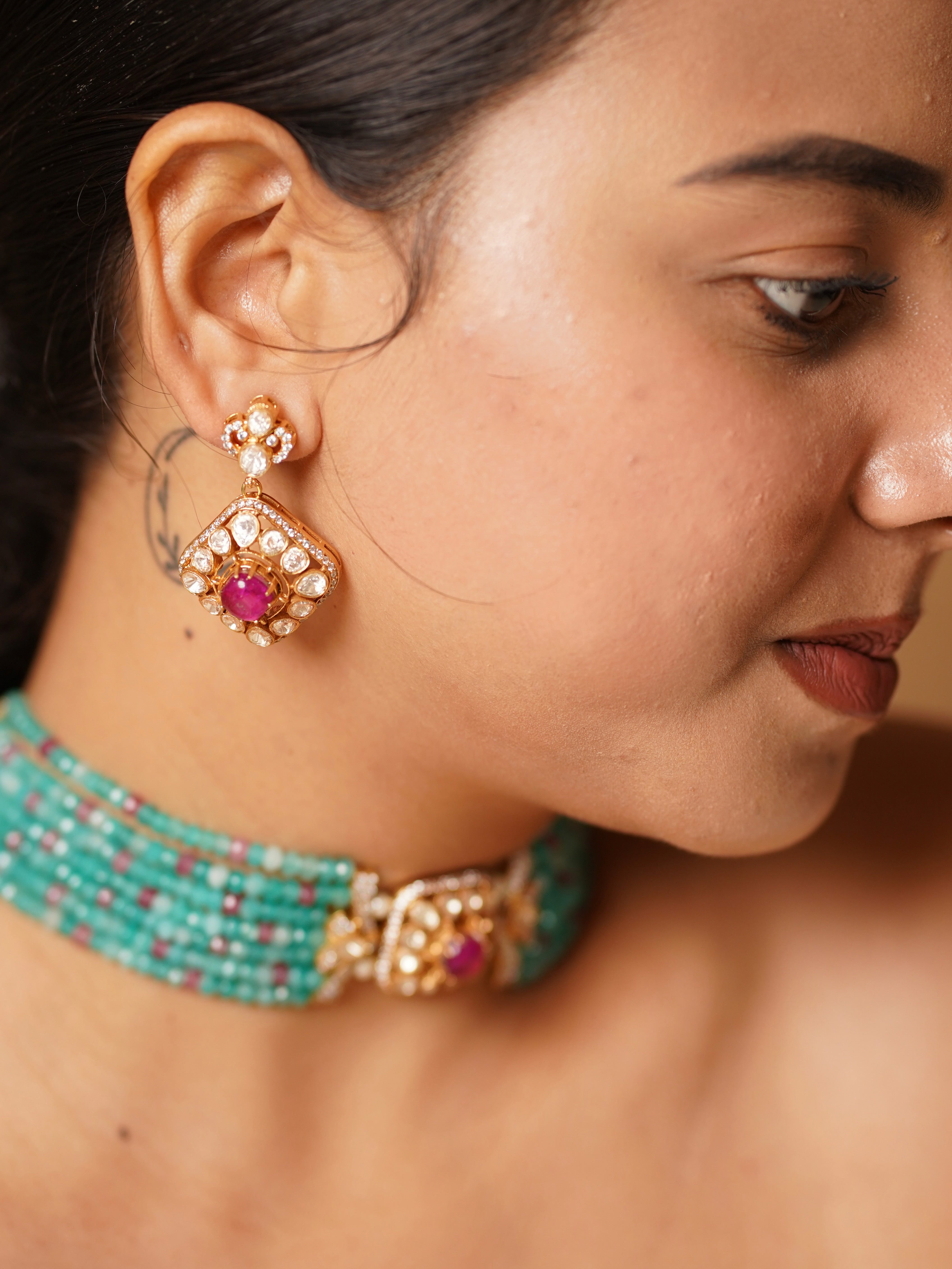 Close-up of kundan choker with green stones and pearl drop embellishments