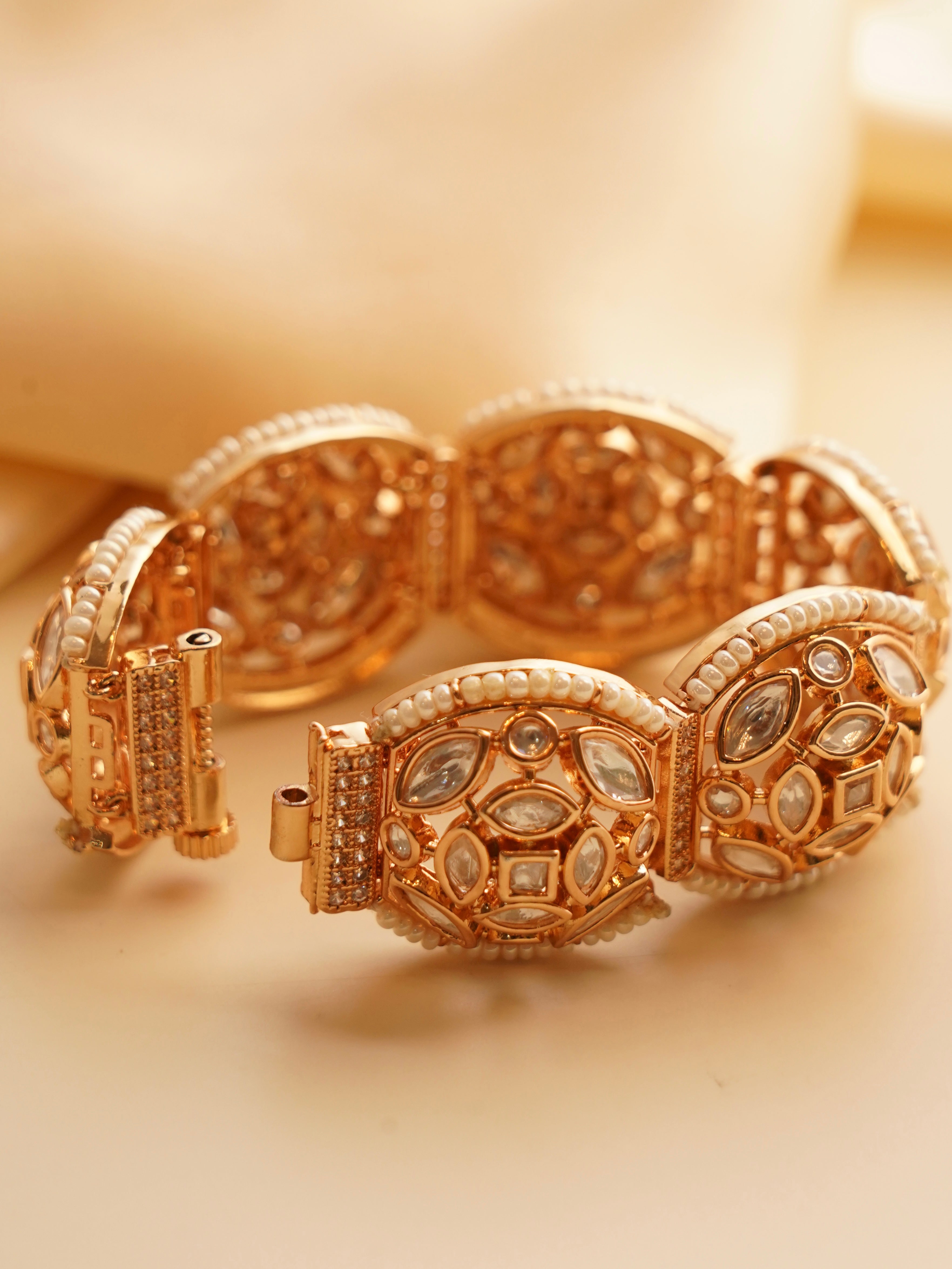 Close-up of gold-toned kundan bracelet showcasing pearl and gemstone embellishments