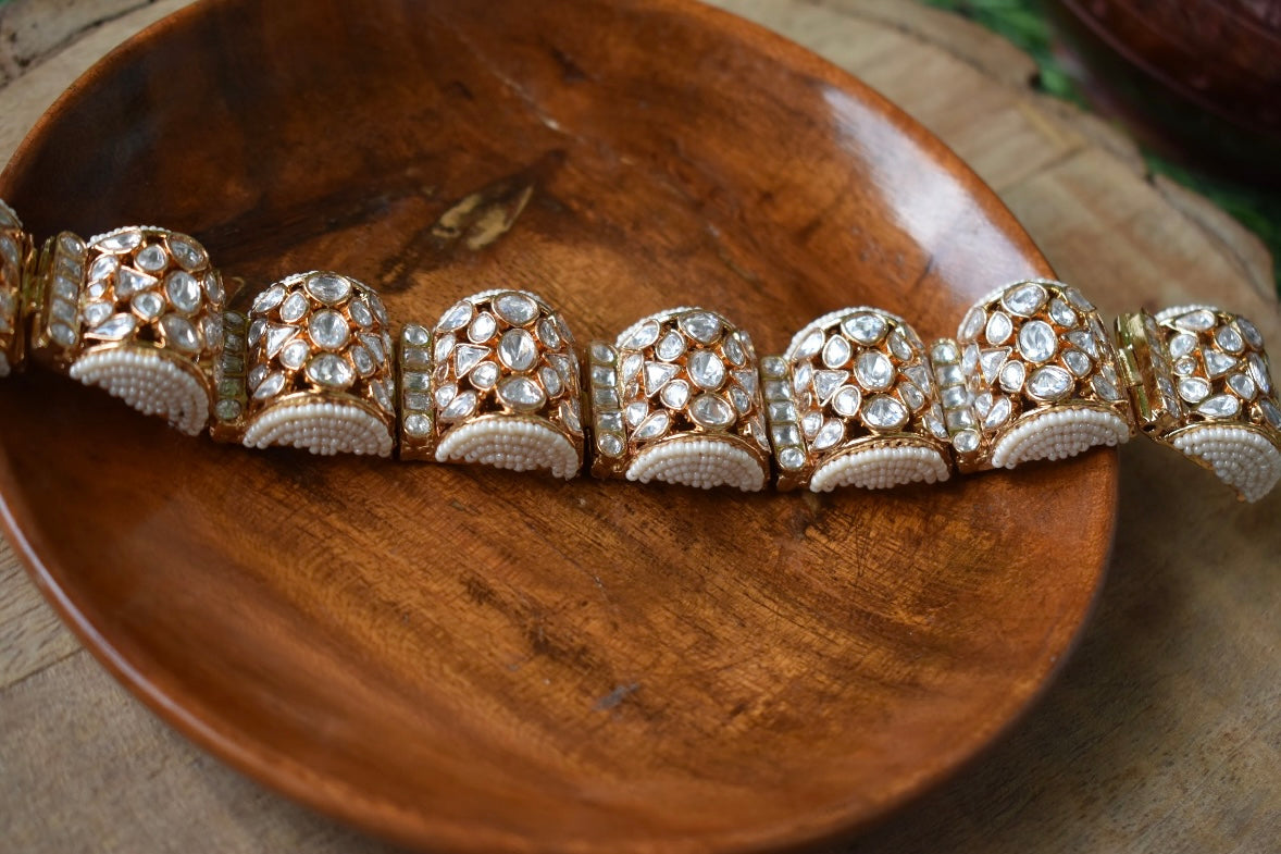 Close-up of floral moissanite bracelet showing pearl clusters and polished gold finish