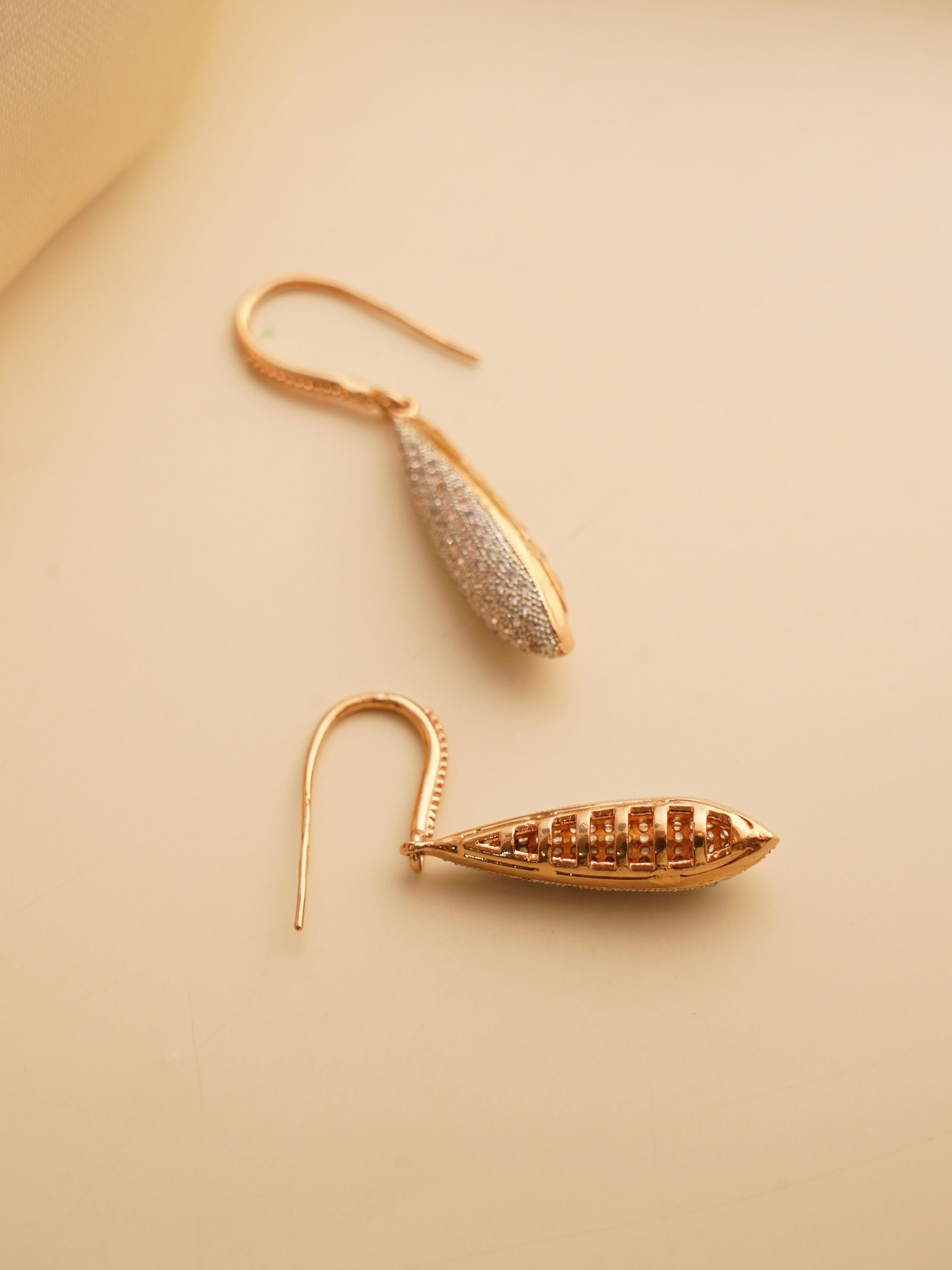 Front view of delicate zirconia-studded dangles with high-shine rose gold finish