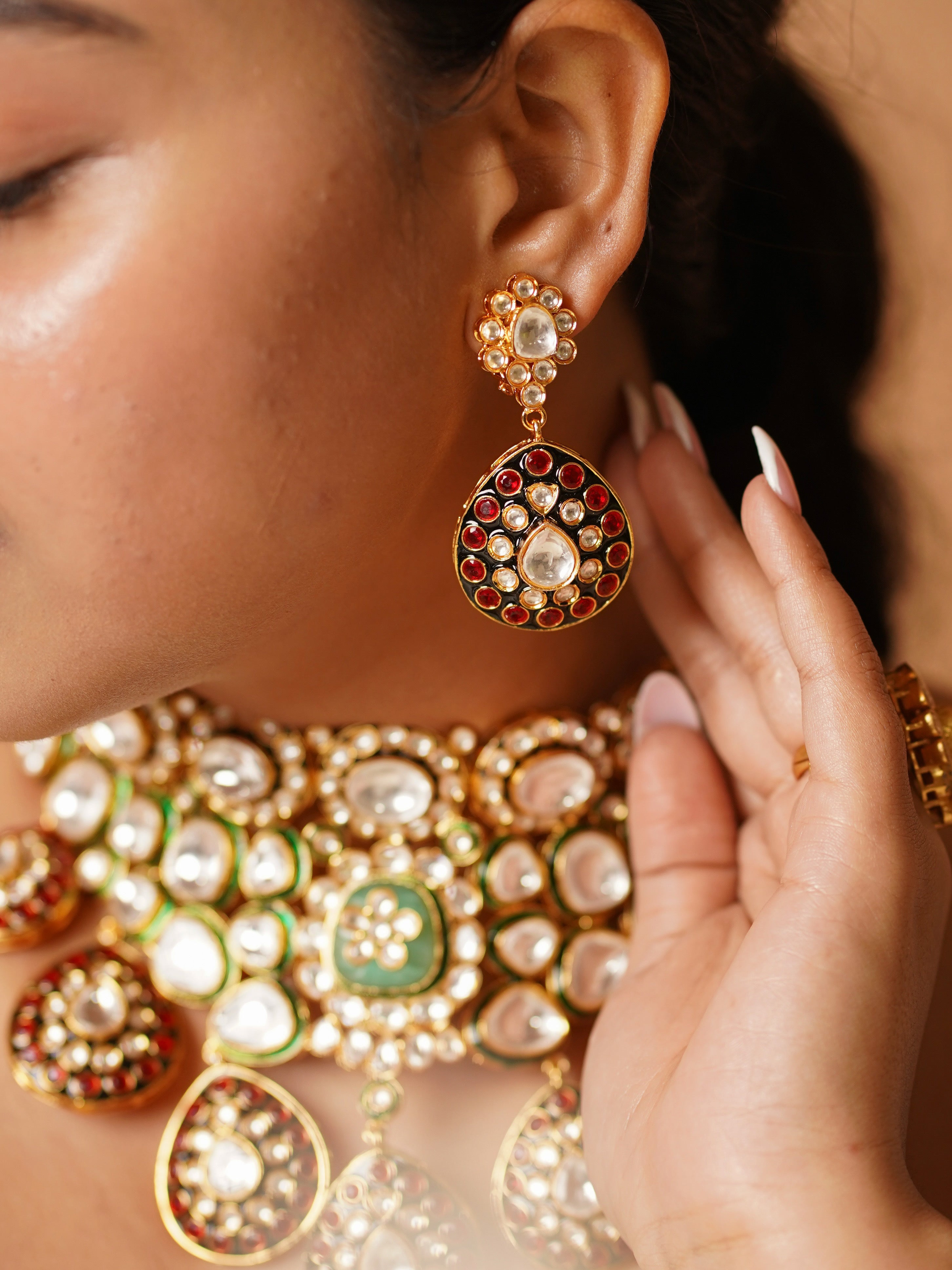 Close-up of earrings and pendant detailing with polki and ruby accents in gold setting
