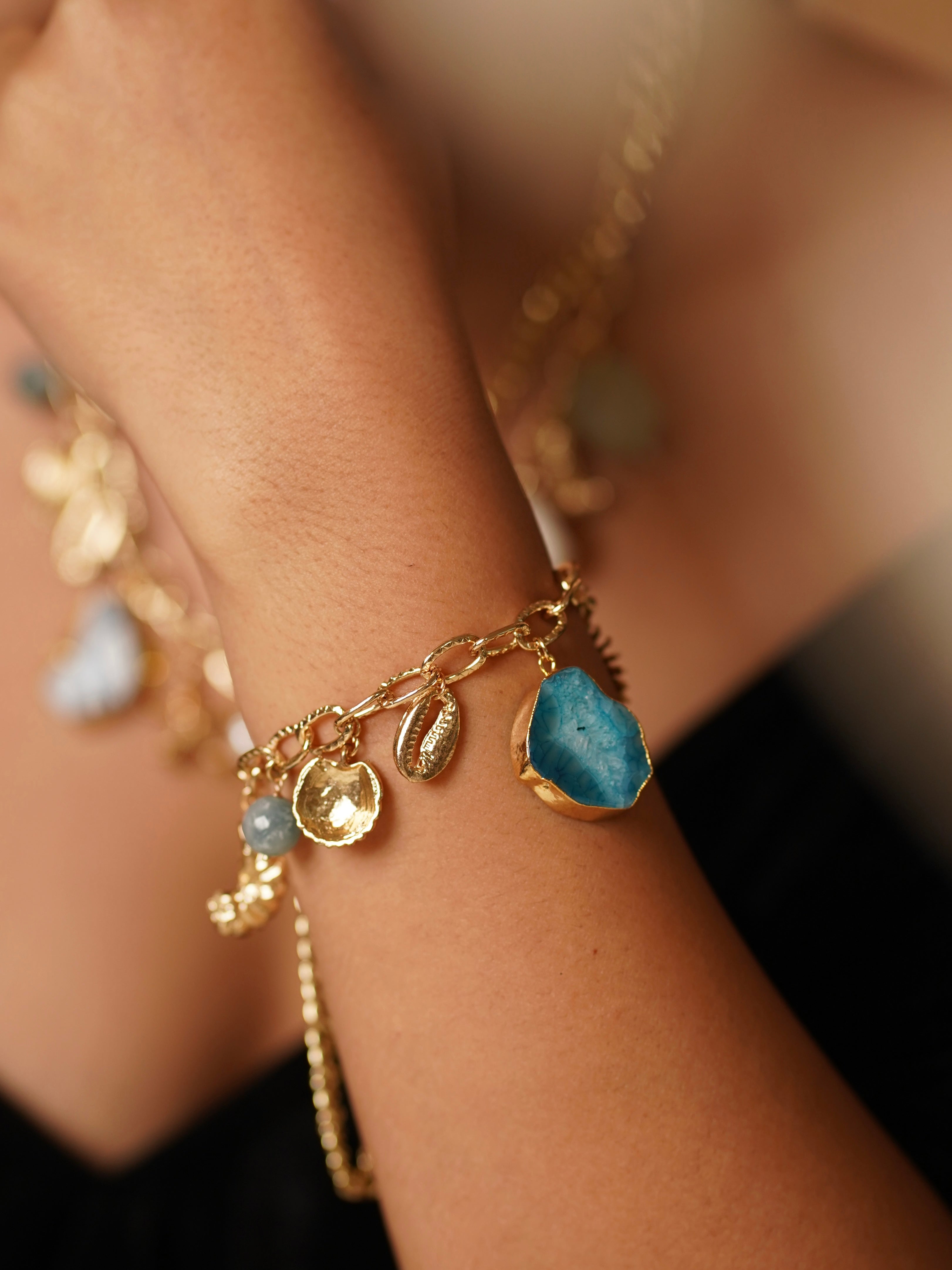 Side angle of charm necklace with marine-inspired detailing and layered beads