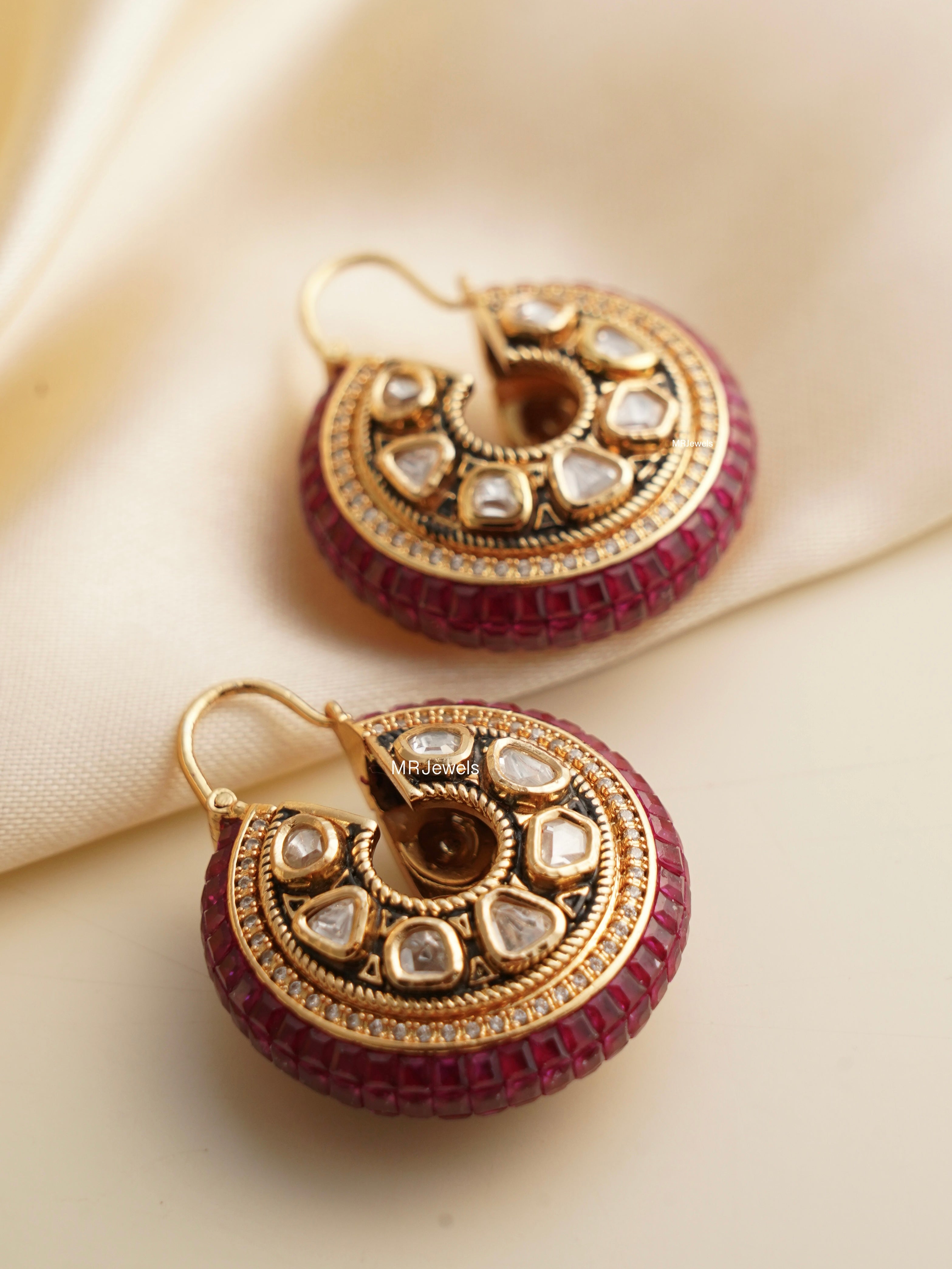 close-up of vilandi earrings with ruby stones and intricate gold design