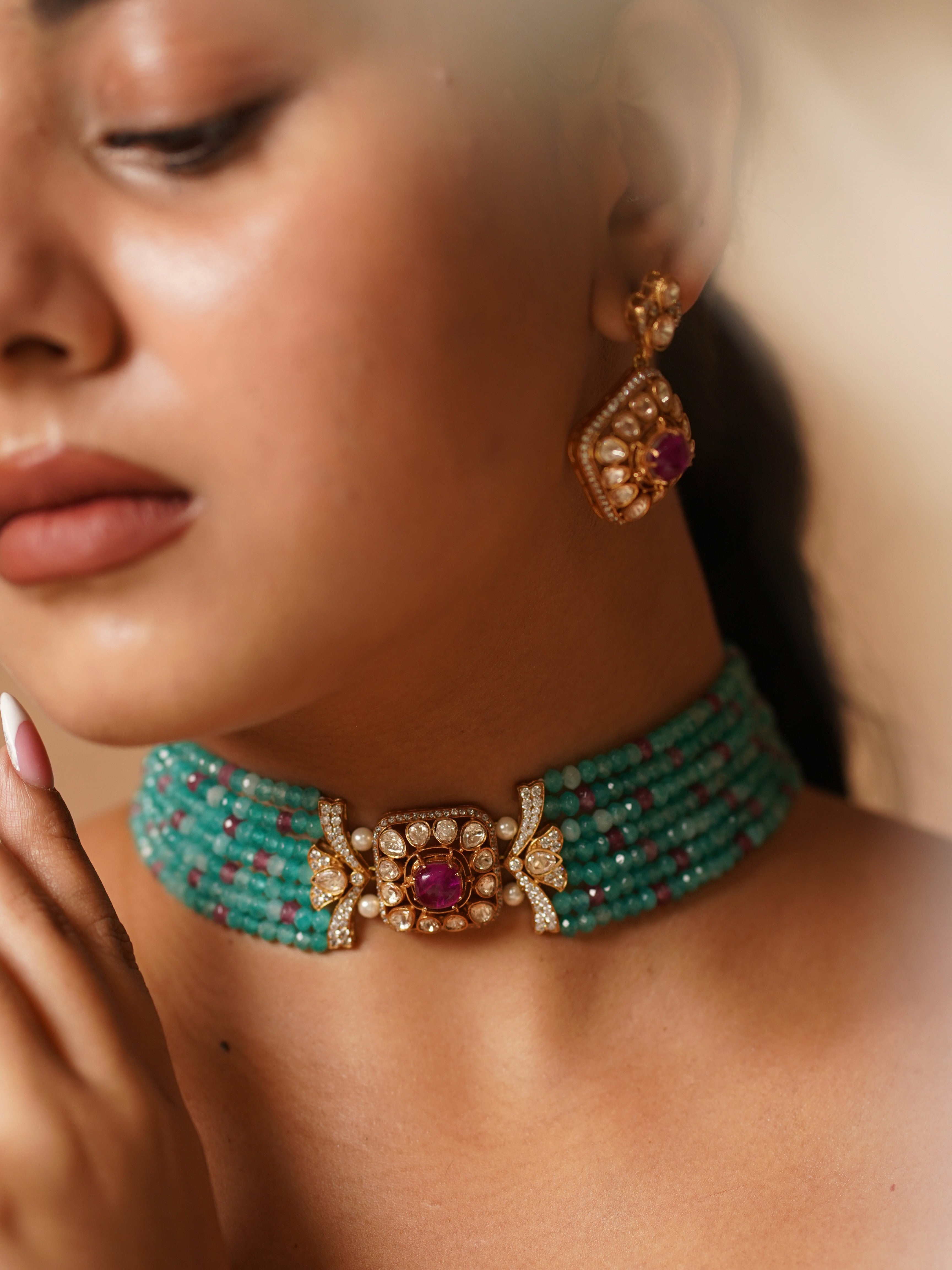 Side angle of emerald choker necklace with matching kundan earrings