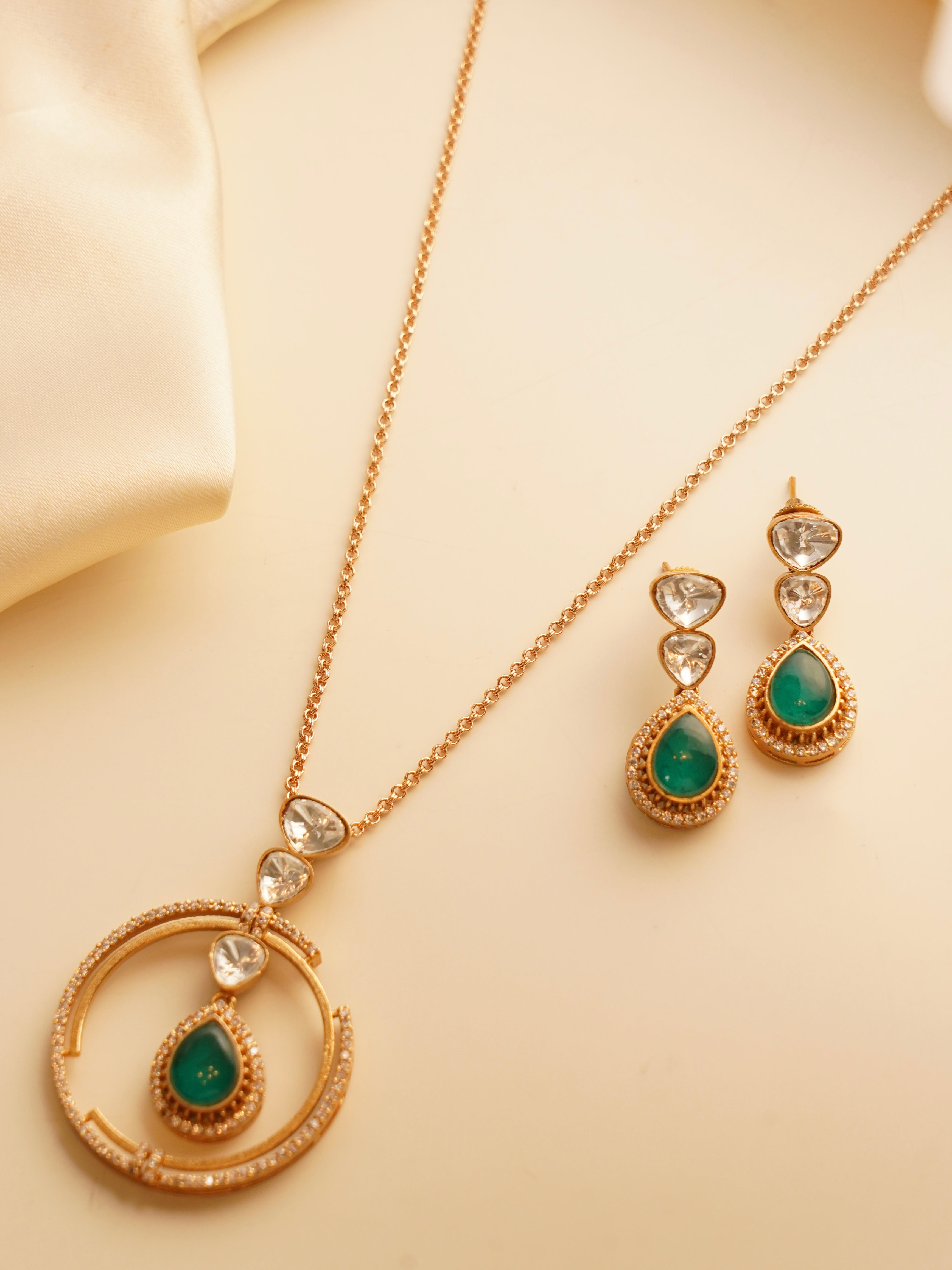 Side view of emerald green Ziva set showing moissanite halo and gold-plated finish