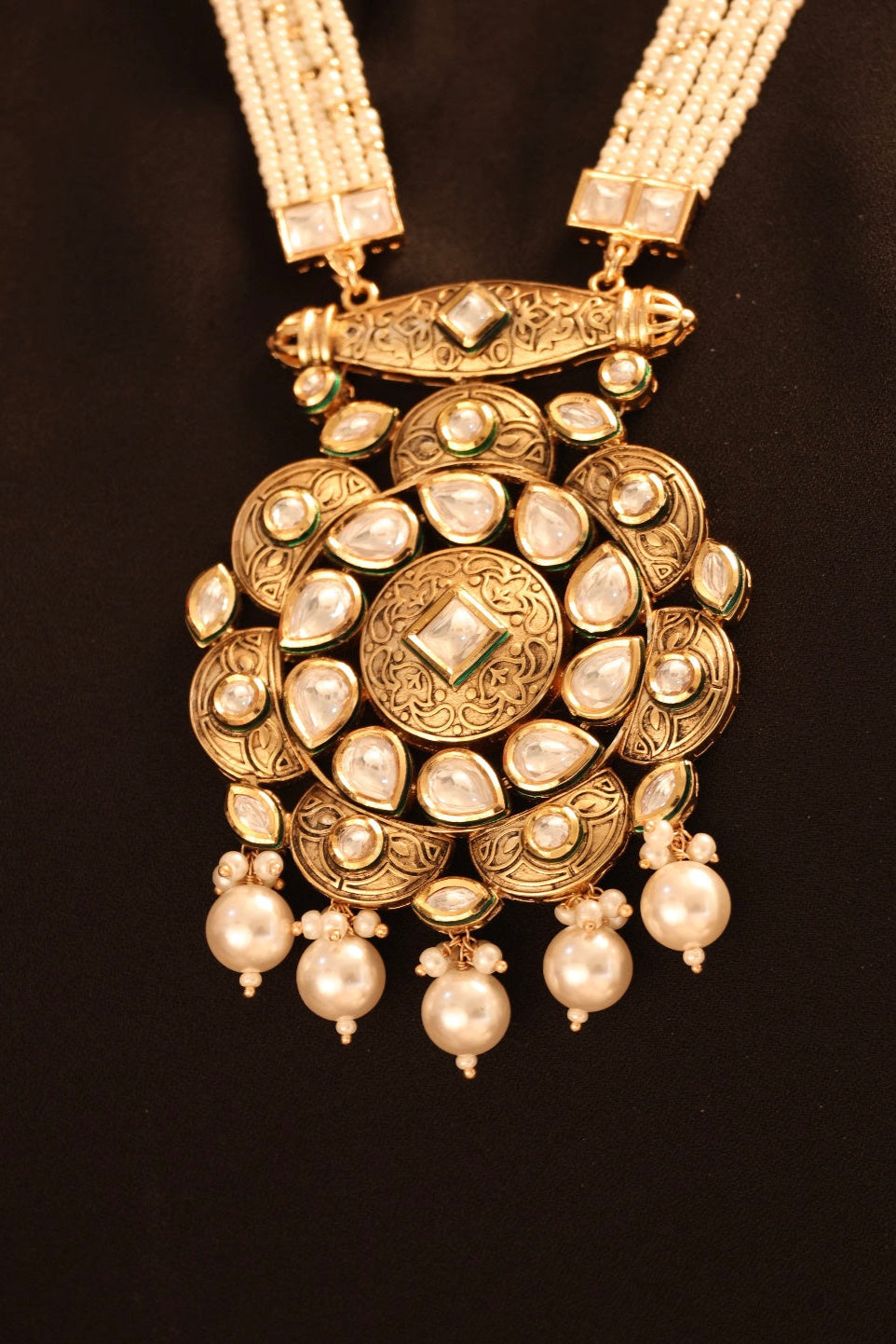 Side angle of pearl kundan necklace with antique gold accents and matching earrings