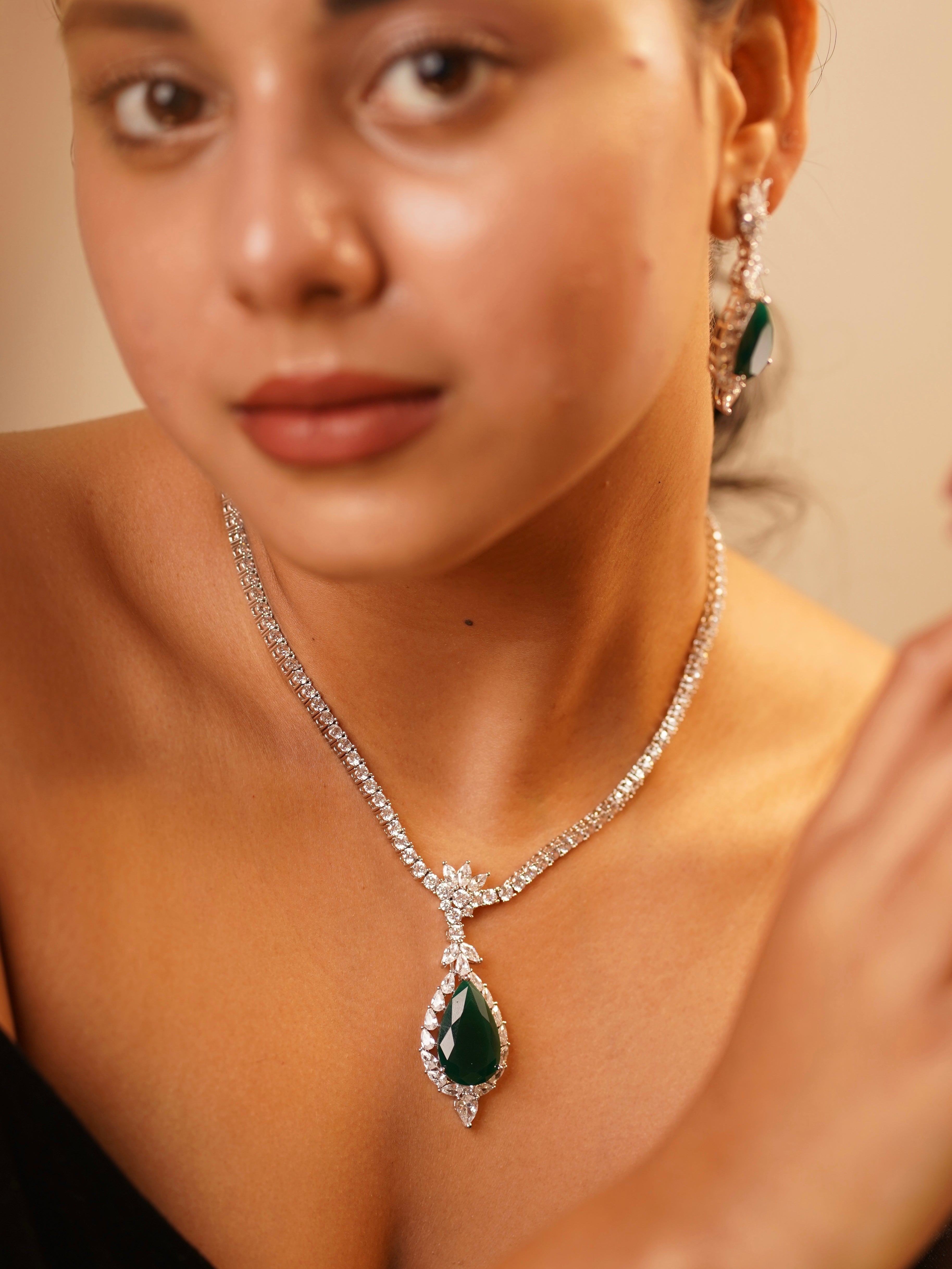 Emerald elegance necklace set with cascading green stones and diamond borders