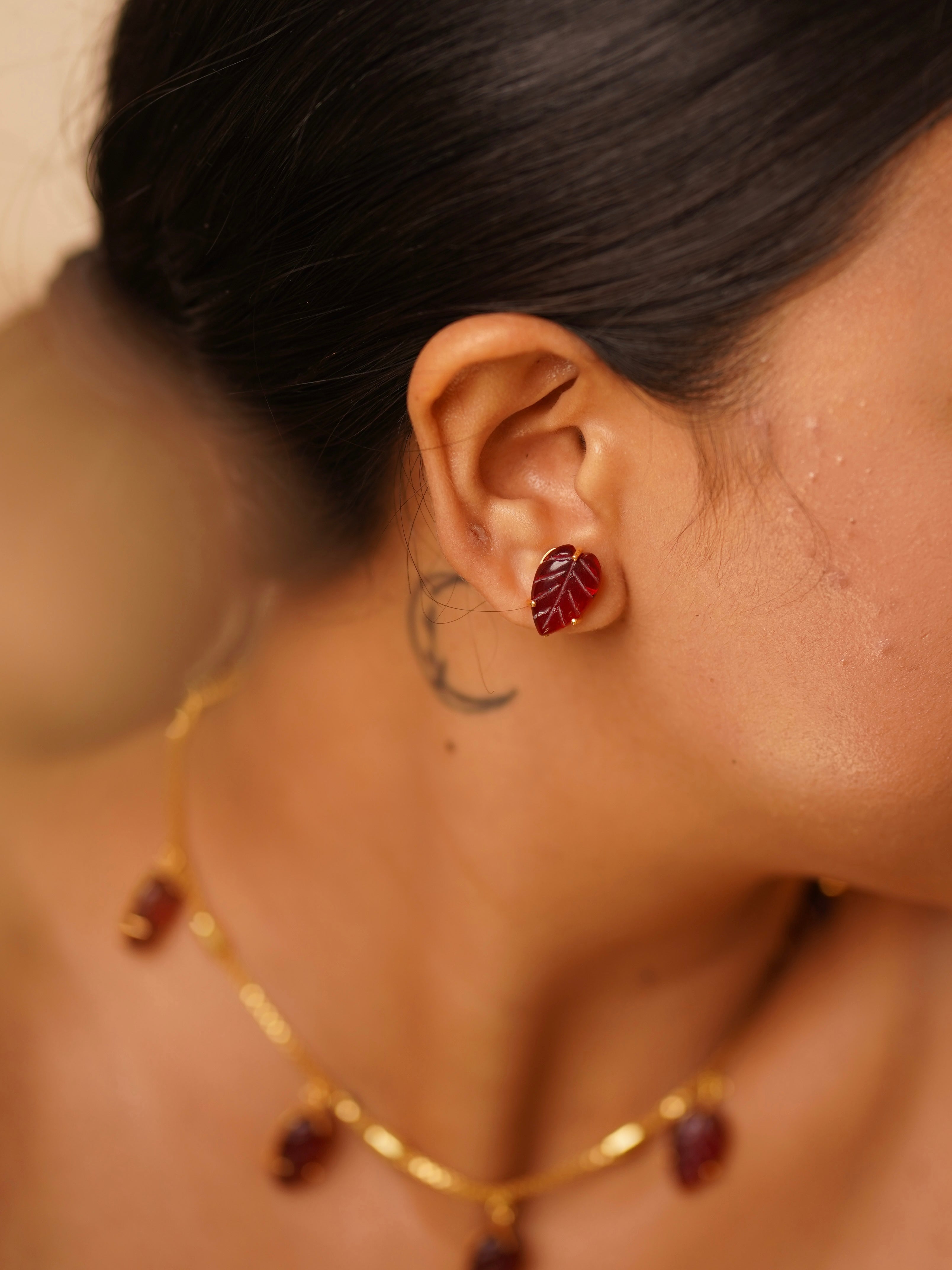 Detailed view of necklace set with red garnet accents and gold-tone chain