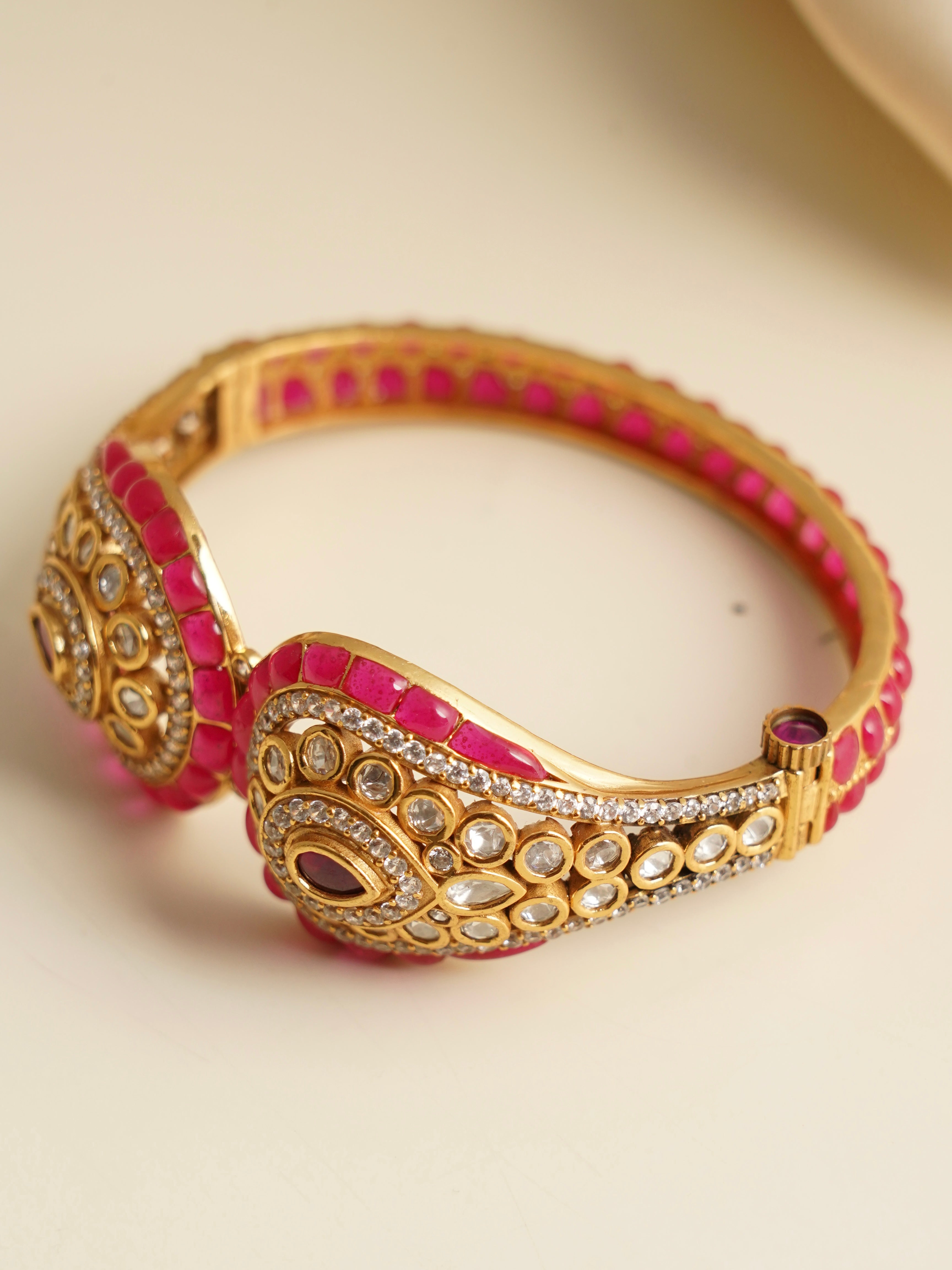 Side profile of kada highlighting green enamel detailing and polished gold plating