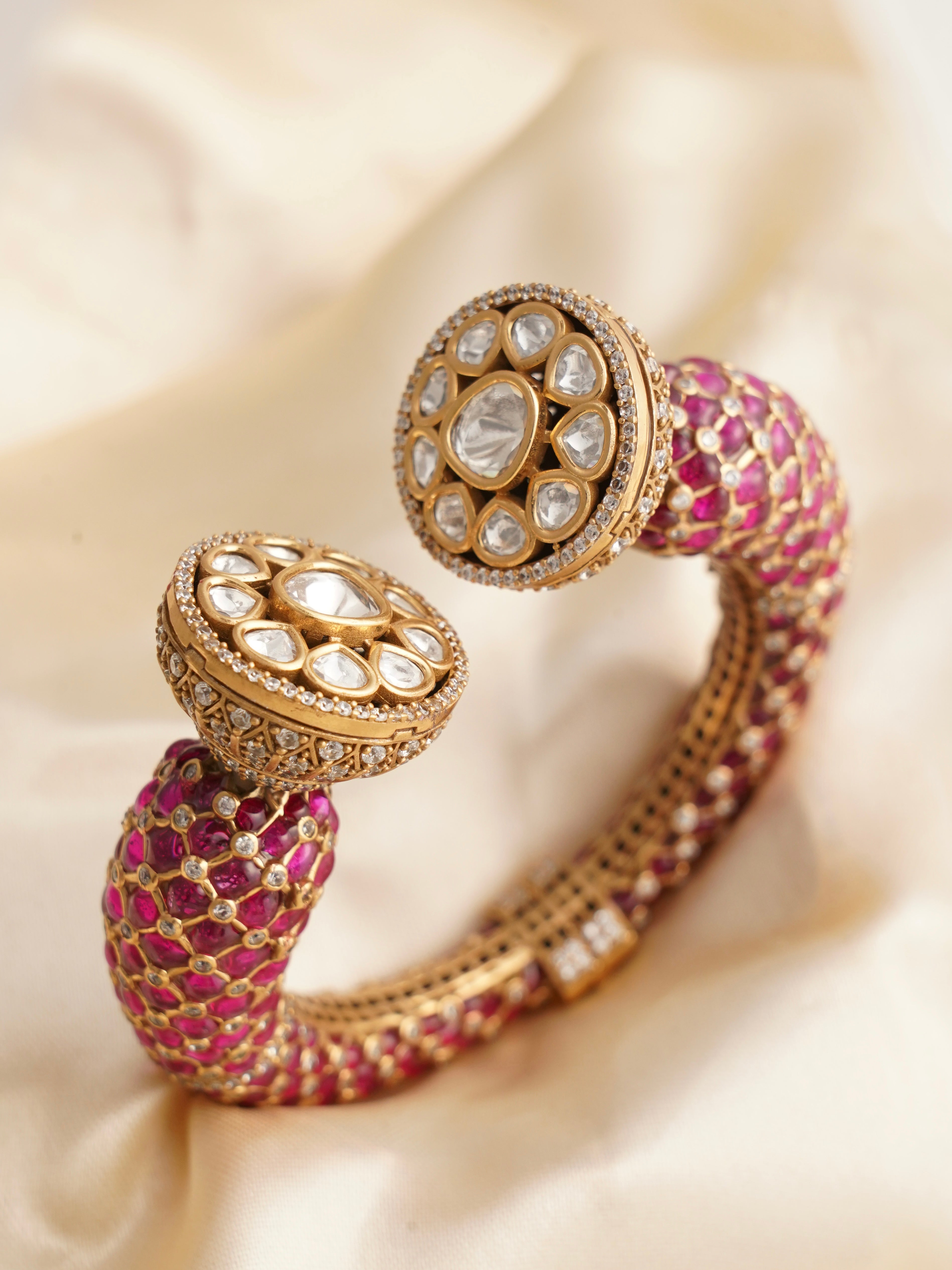 Top view of gold-finish kada with enamel, kundan, and cubic zirconia design