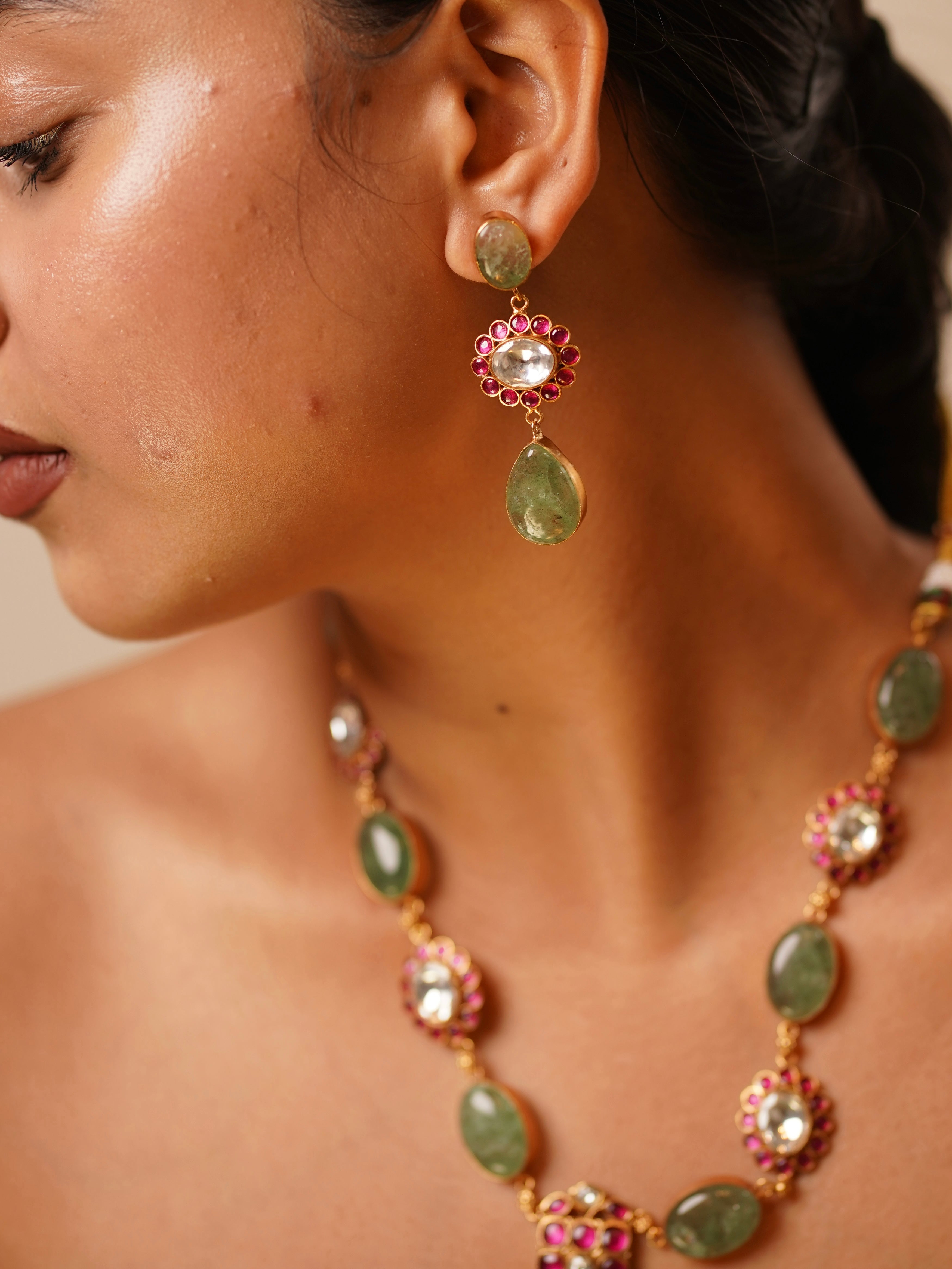 side profile of kabachino and ruby kundan necklace paired with elegant earrings