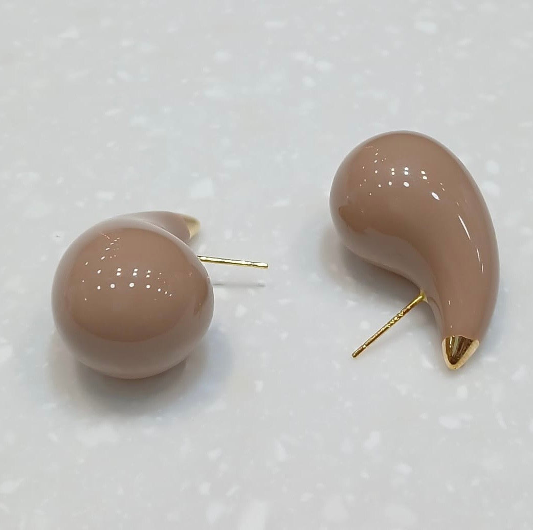 Side profile of abstract studs showcasing smooth curves and reflective gold surface